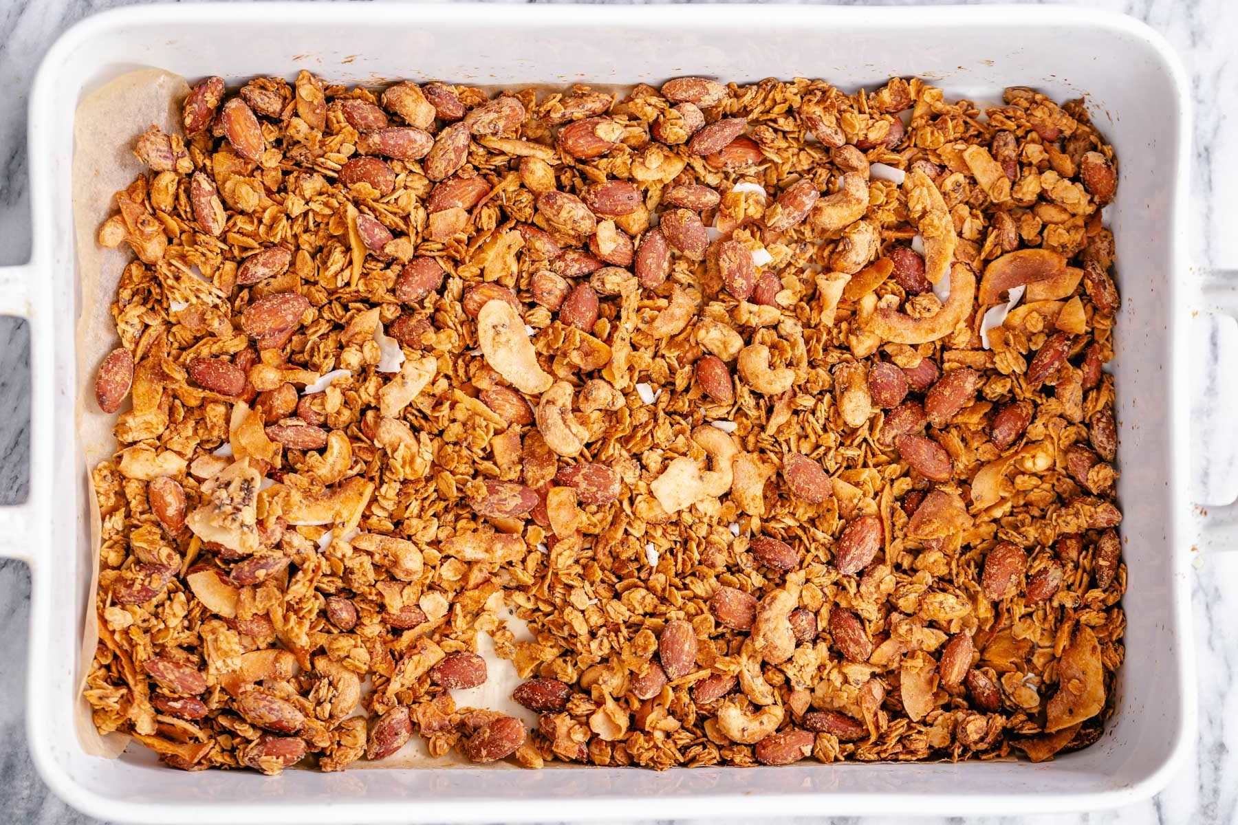 coconut granola a white casserole dish filled with baked vegan granola