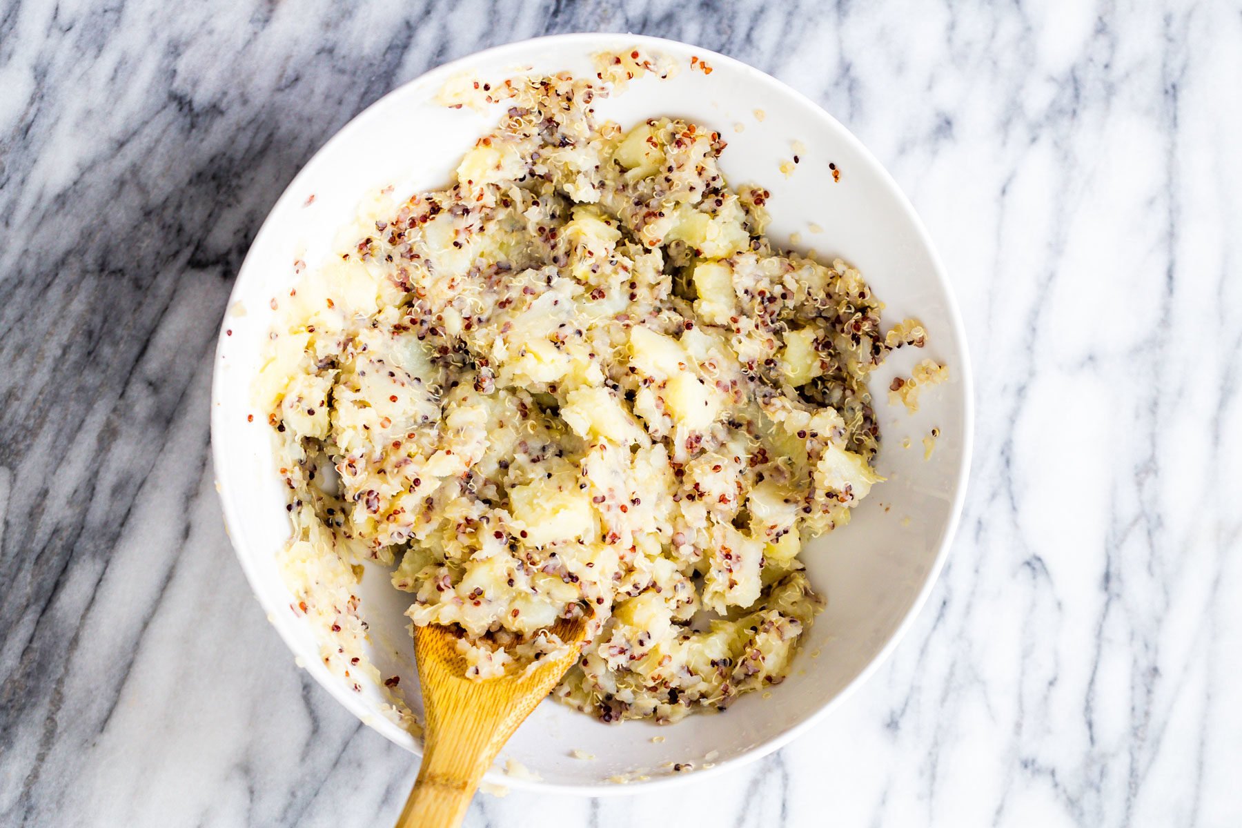vegan potato waffles potatoes and quinoa being mashed in a bowl