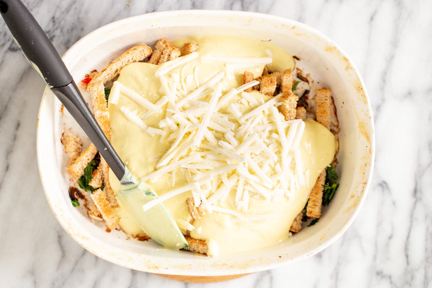 vegan breakfast casserole vegan cheese shreds being sprinkled on top of vegan breakfast casserole
