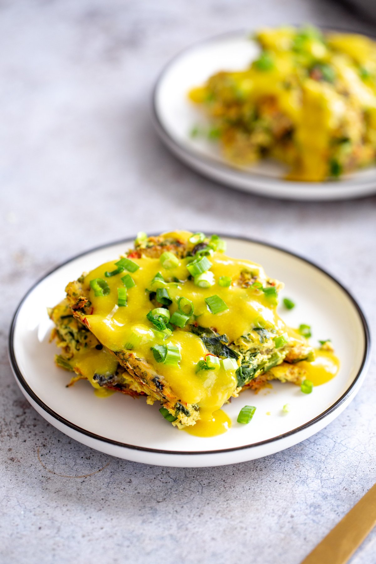 vegan breakfast casserole overhead shot of a serving of vegan breakfast casserole served with vegan hollandaise