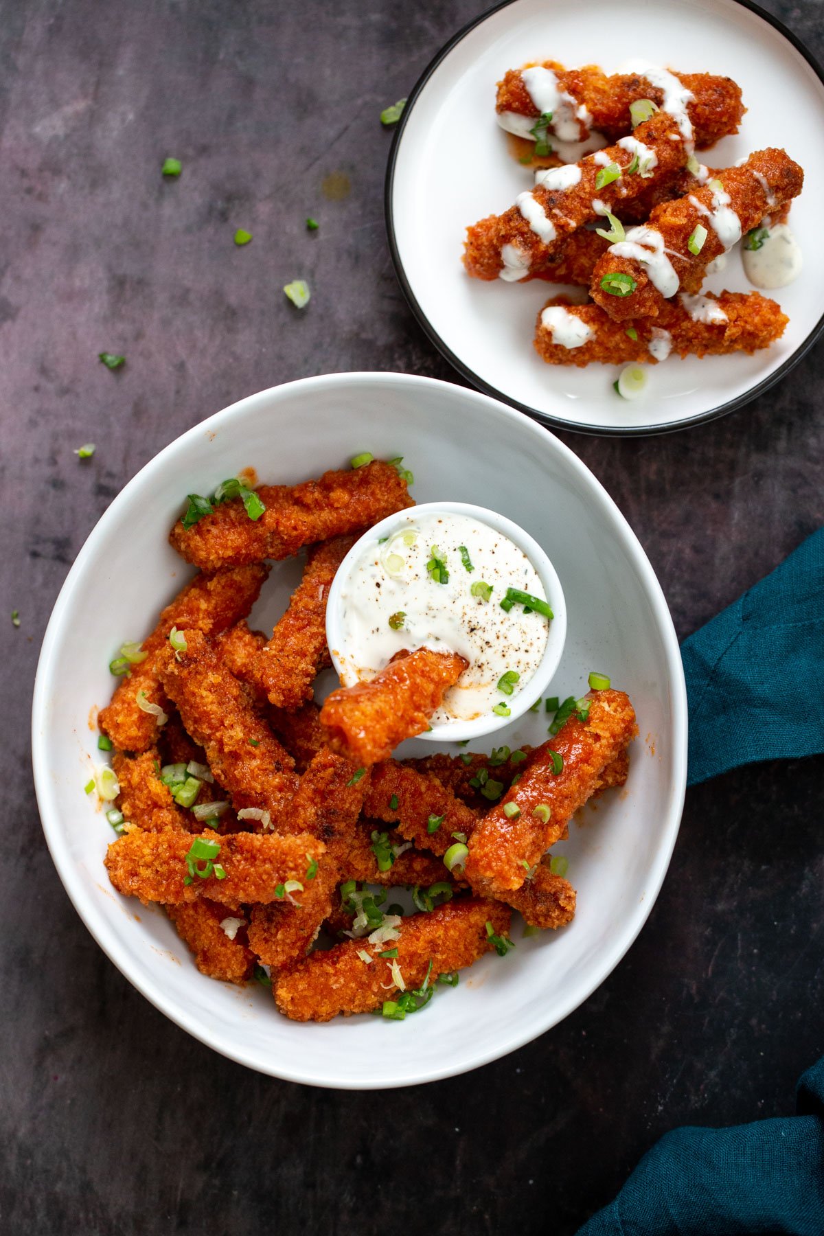 tofu wings a bowl with firecracker tofu wings served with a dip and a small plate with vegan tofu wings drizzled with ranch
