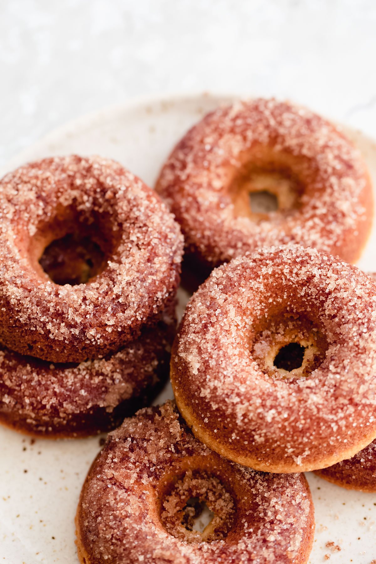 glutenfree donuts recipe vegan glutenfree vanilla donuts with cinnamon sugar topping on a white plate