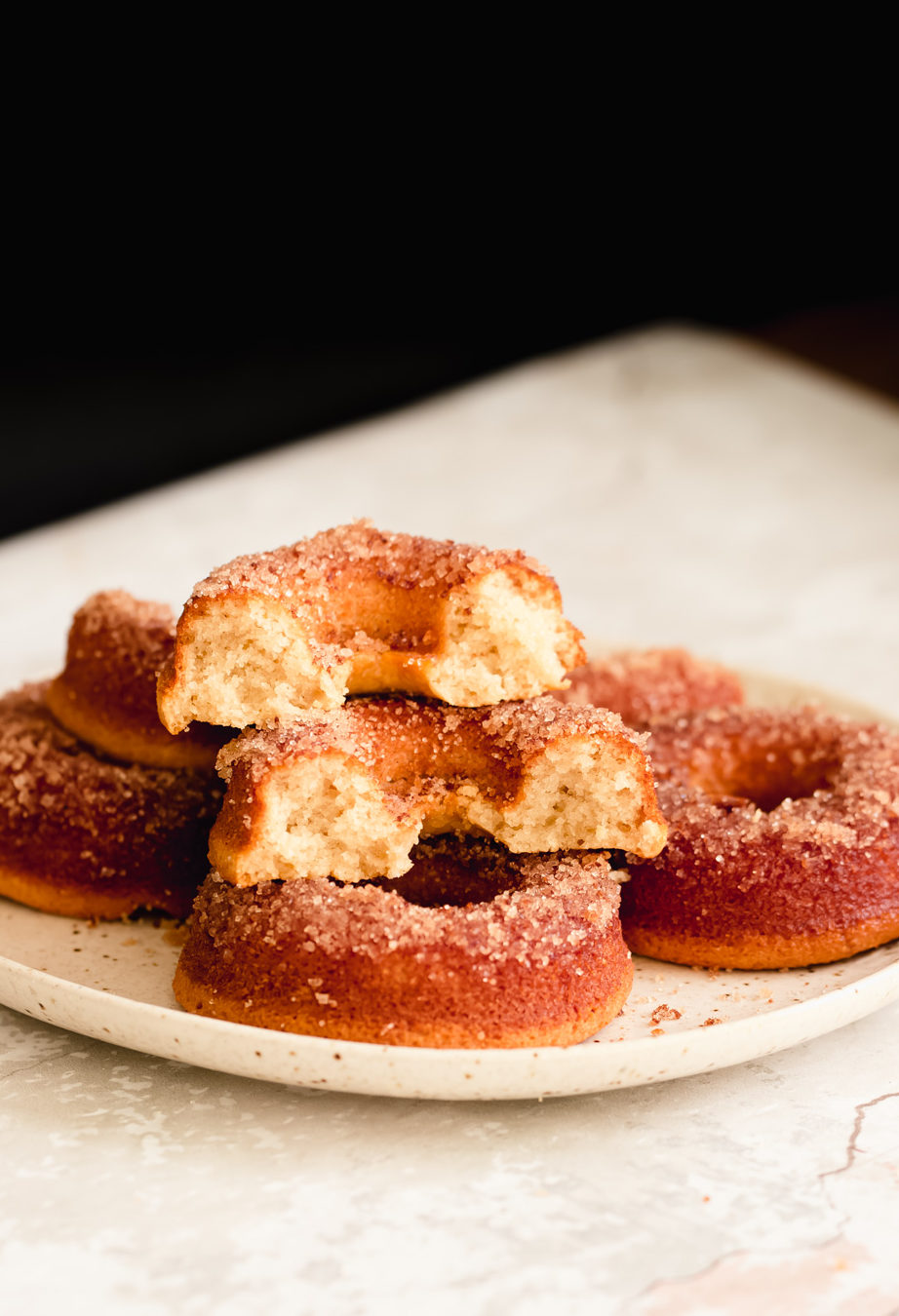 glutenfree donuts recipe side view of a plate with glutenfree vanilla donuts with one donut being cut into half