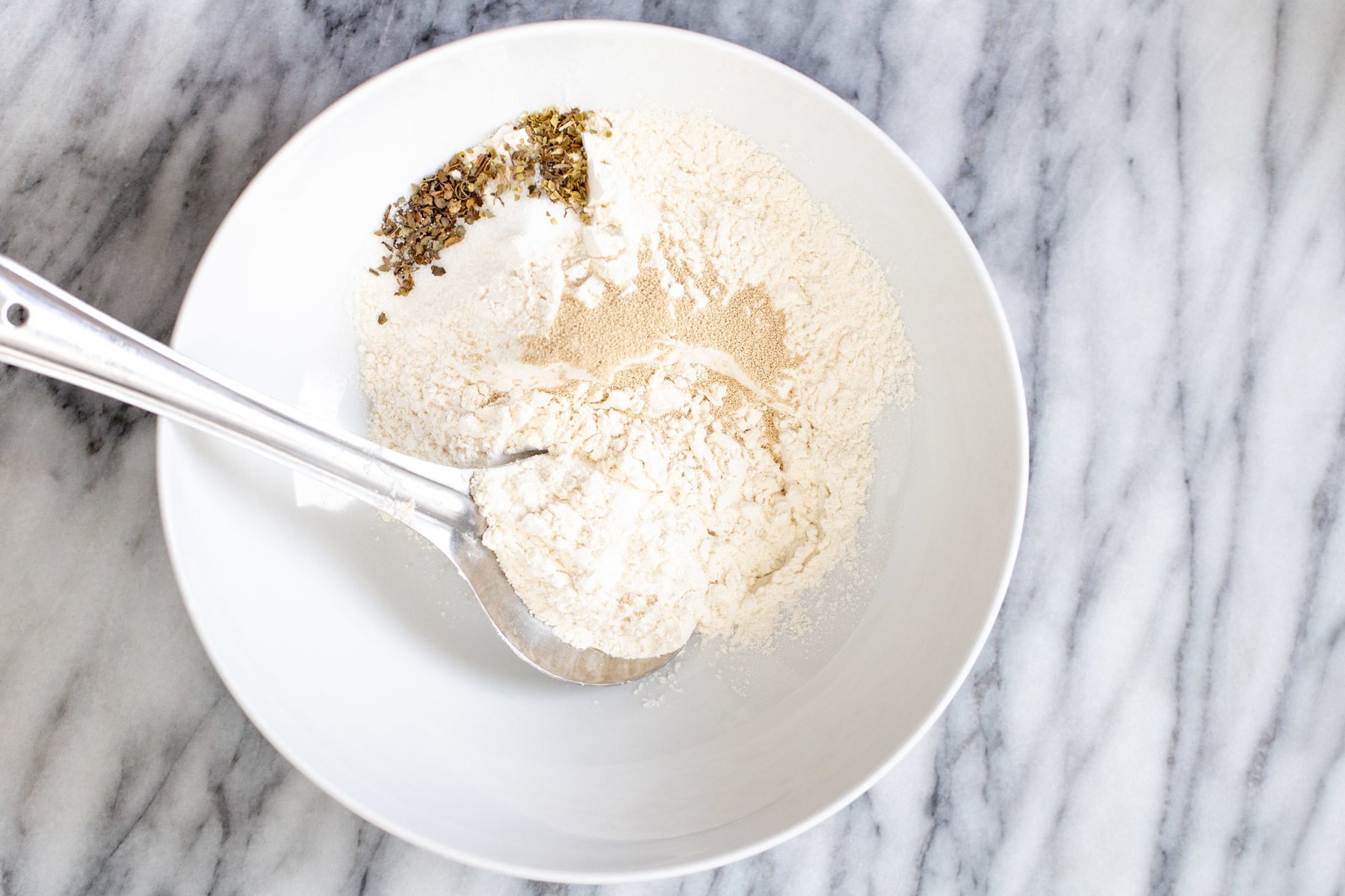 pizza waffles dry ingredients for making vegan pizza waffle batter in a white bowl