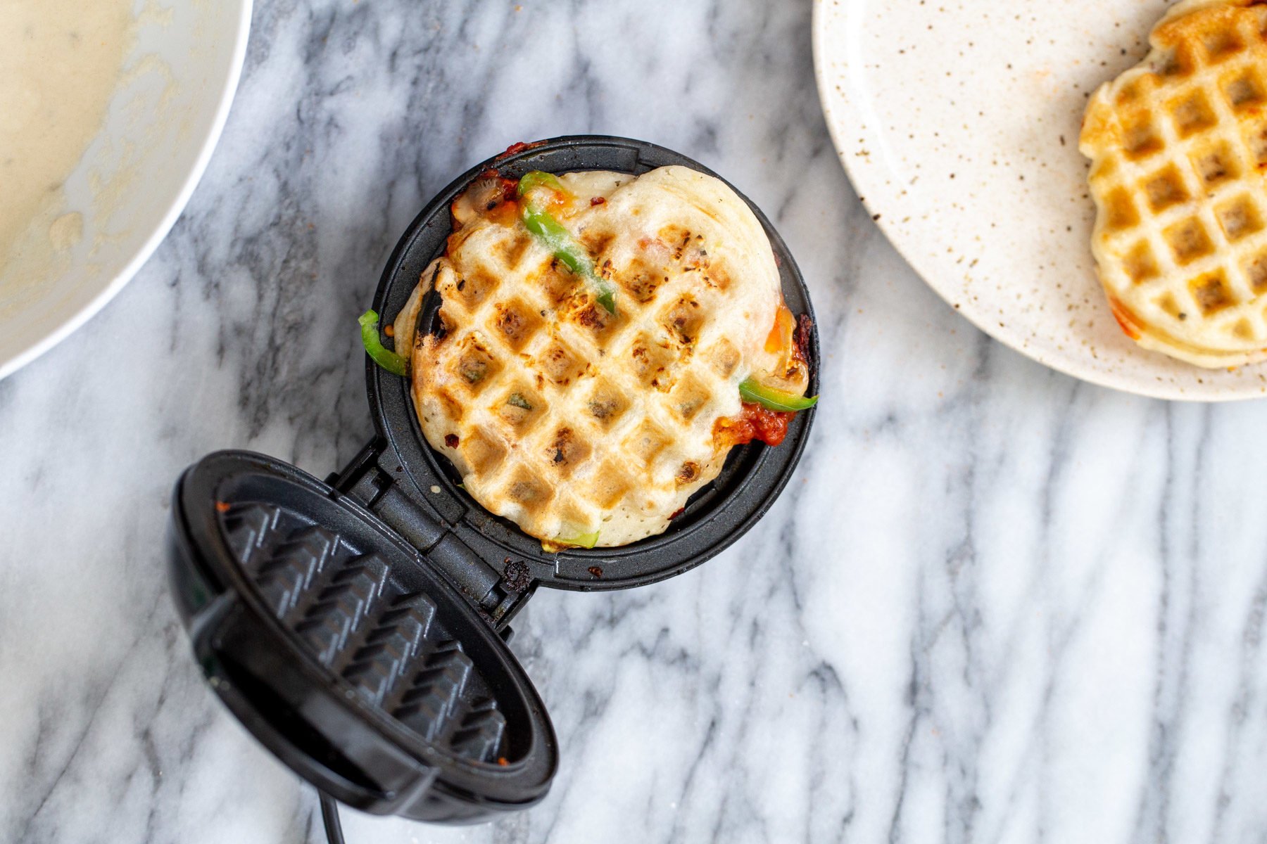 vegan pizza waffle a freshly baked vegan pizza waffle in a waffle iron