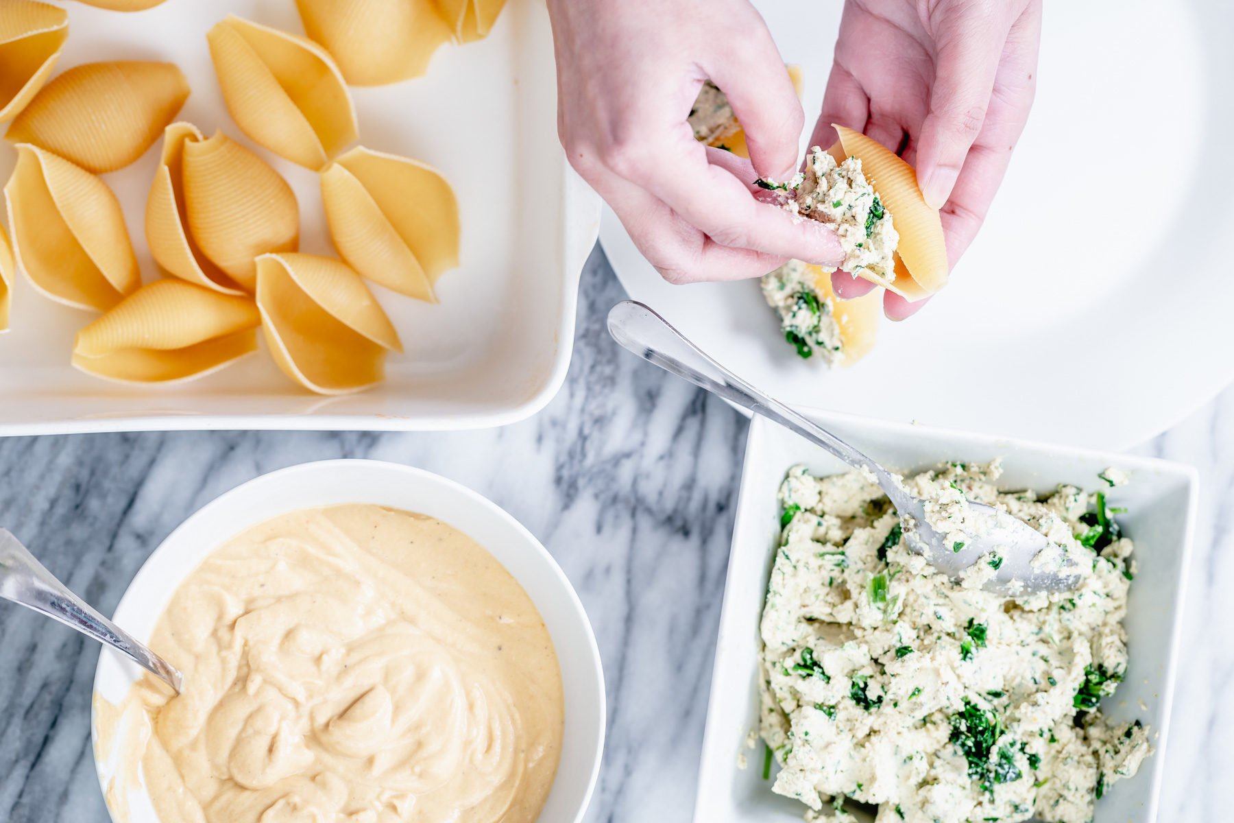 vegan stuffed shells shell pasta being stuffed with tofu ricotta spinach mix