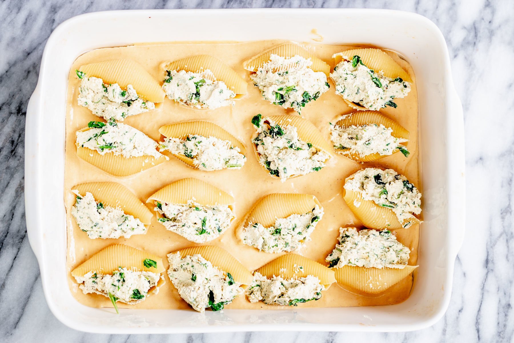 vegan stuffed shells overhead shot of vegan tofu ricotta stuffed shells on butternut squash alfredo