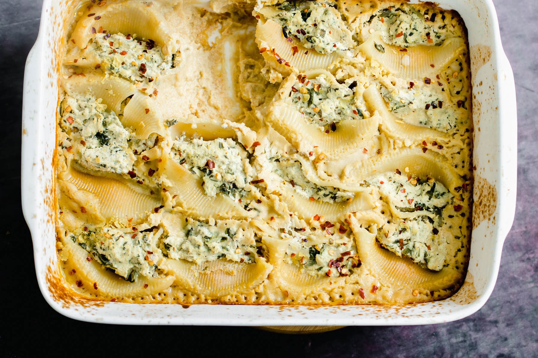 vegan stuffed shells overhead shot of a casserole dish with vegan ricotta stuffed shells with butternut alfredo