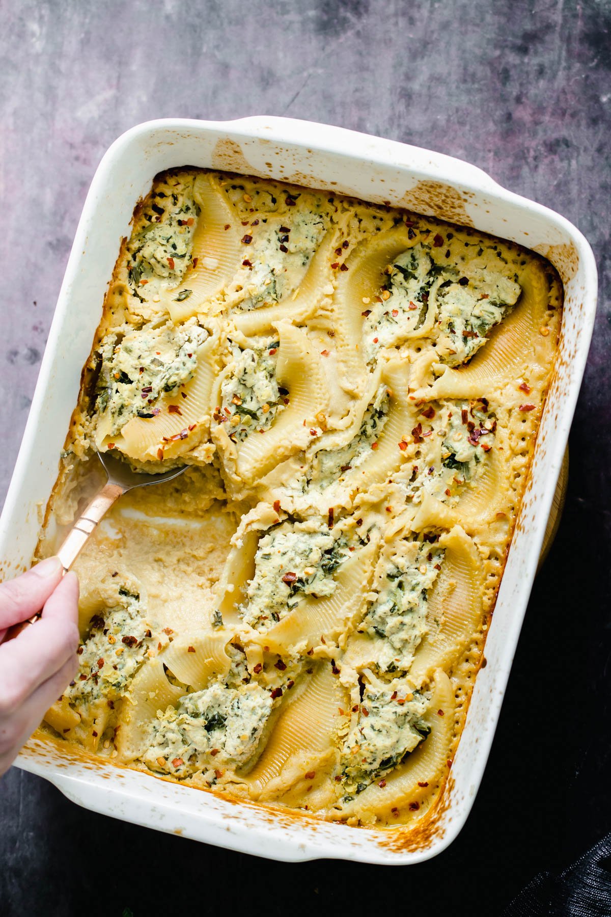 vegan stuffed shells vegan ricotta stuffed shells being served with a silver serving spoon