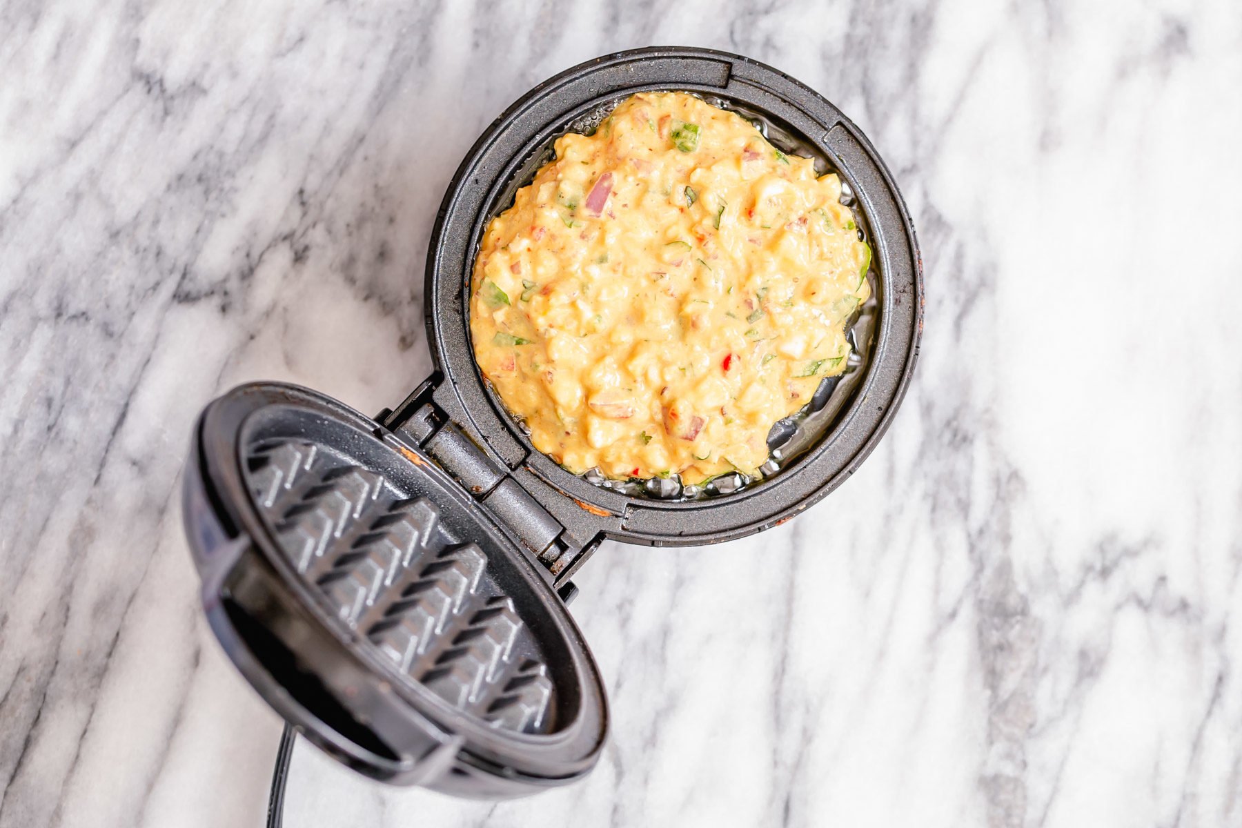 chickpea flour waffle baking in a waffle iron