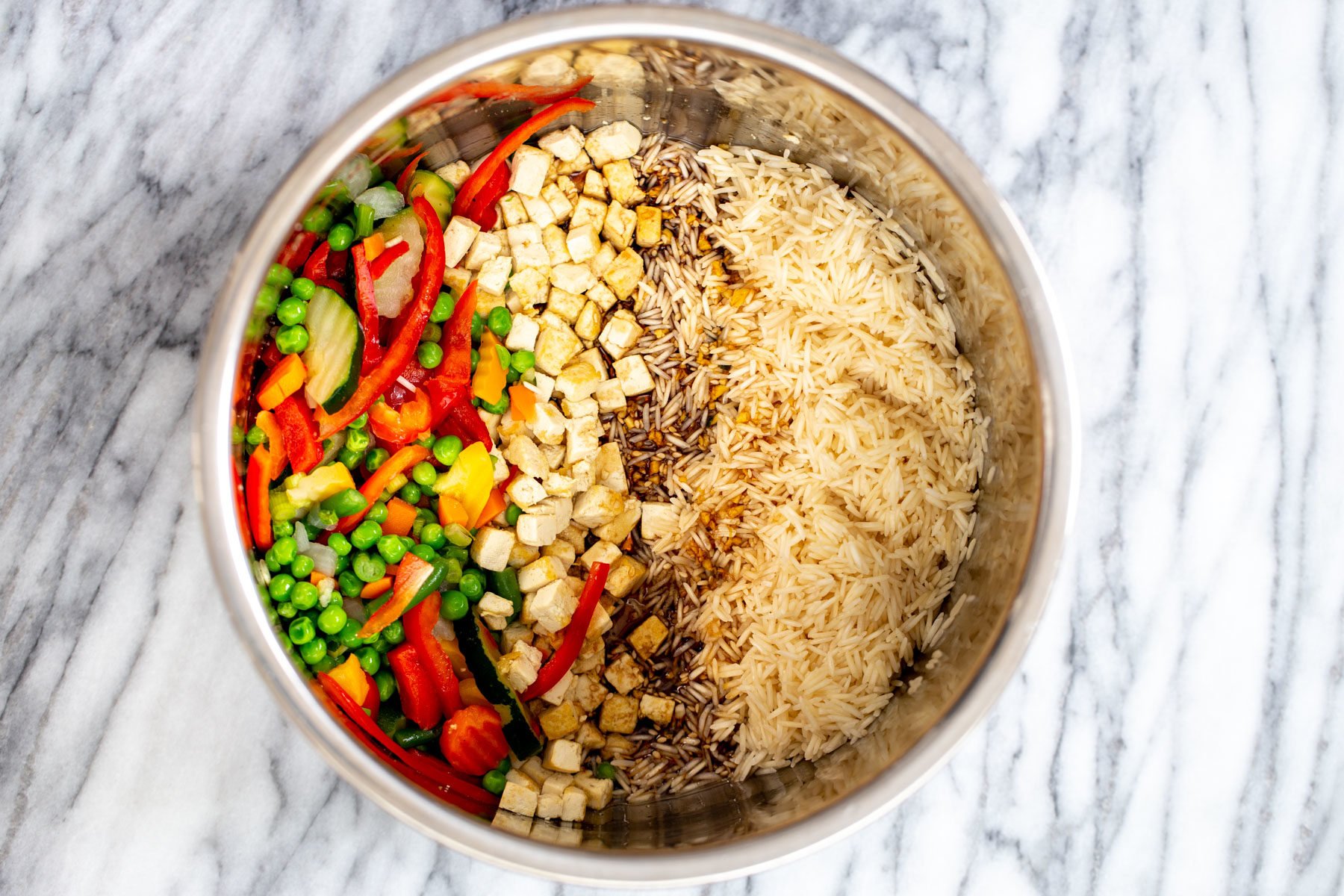rice being mixed with teriyaki sauce, vegetables and tofu in an Instant Pot