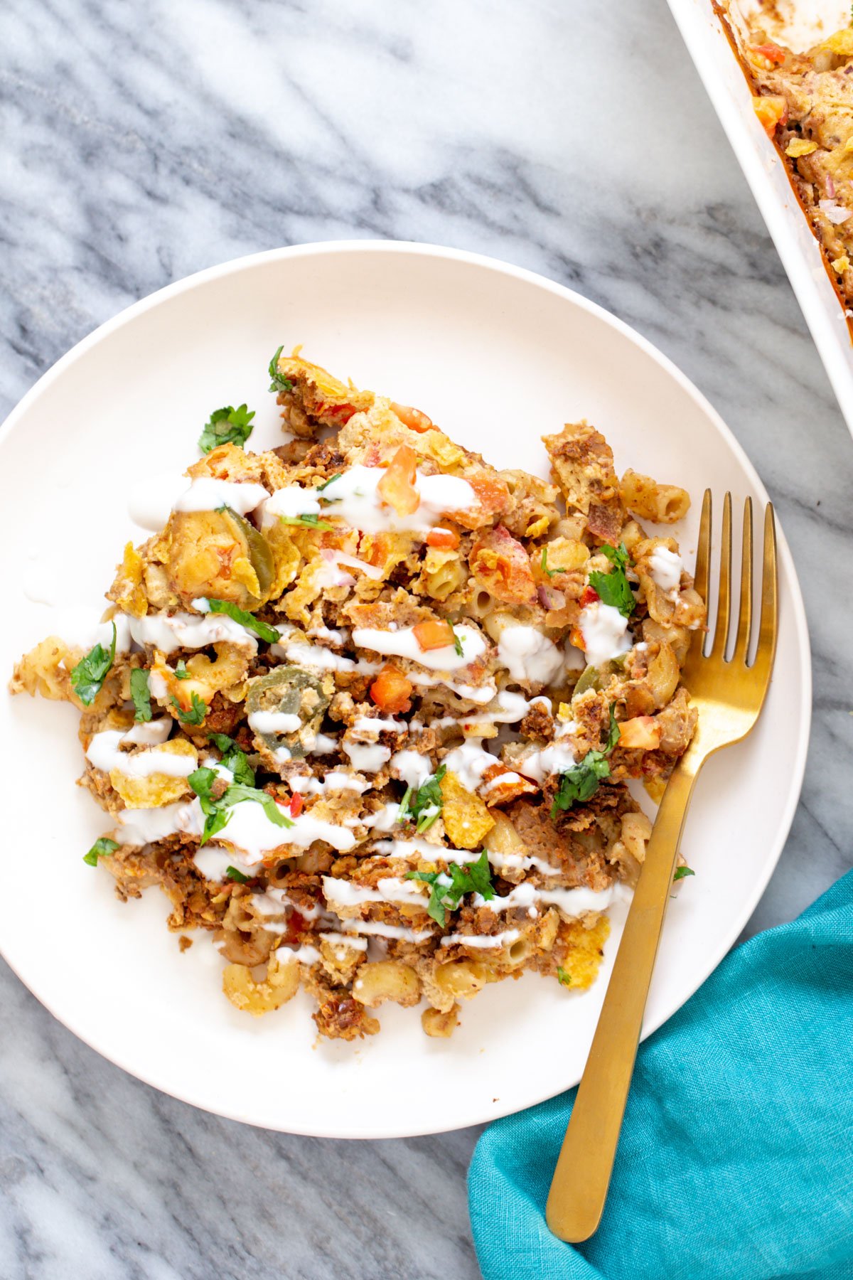 a serving of vegan taco mac and cheese casserole with a fork on the side