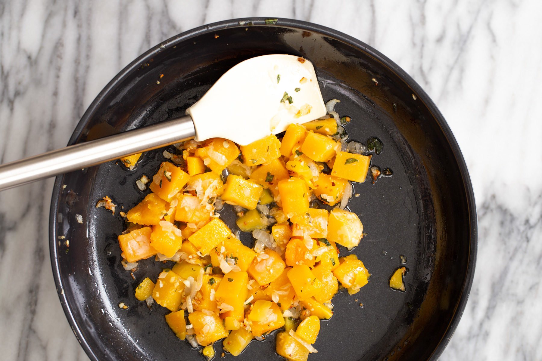butternut squash carbonara  butternut squash being sauteed in a skillet