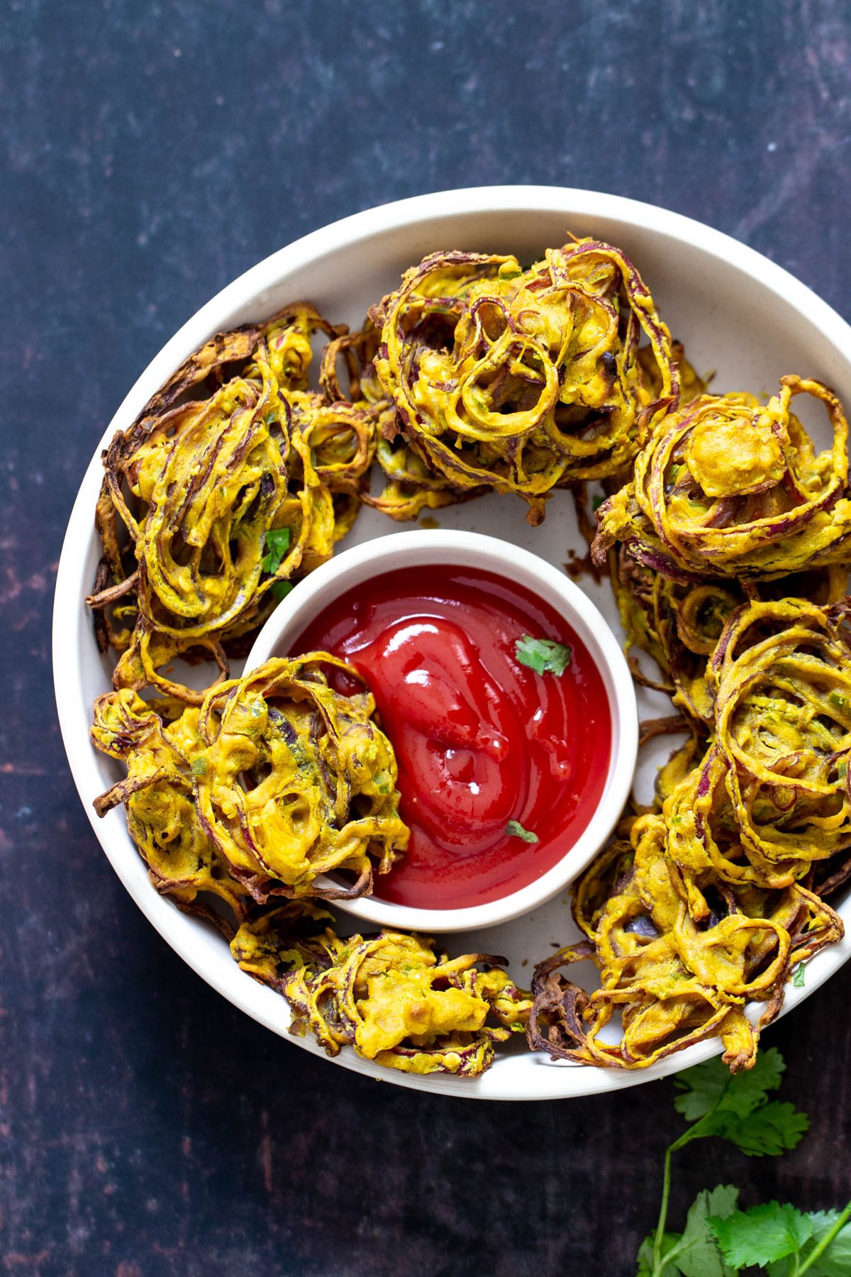 baked pakora a platter with onion pakora served with a small side dish of ketchup