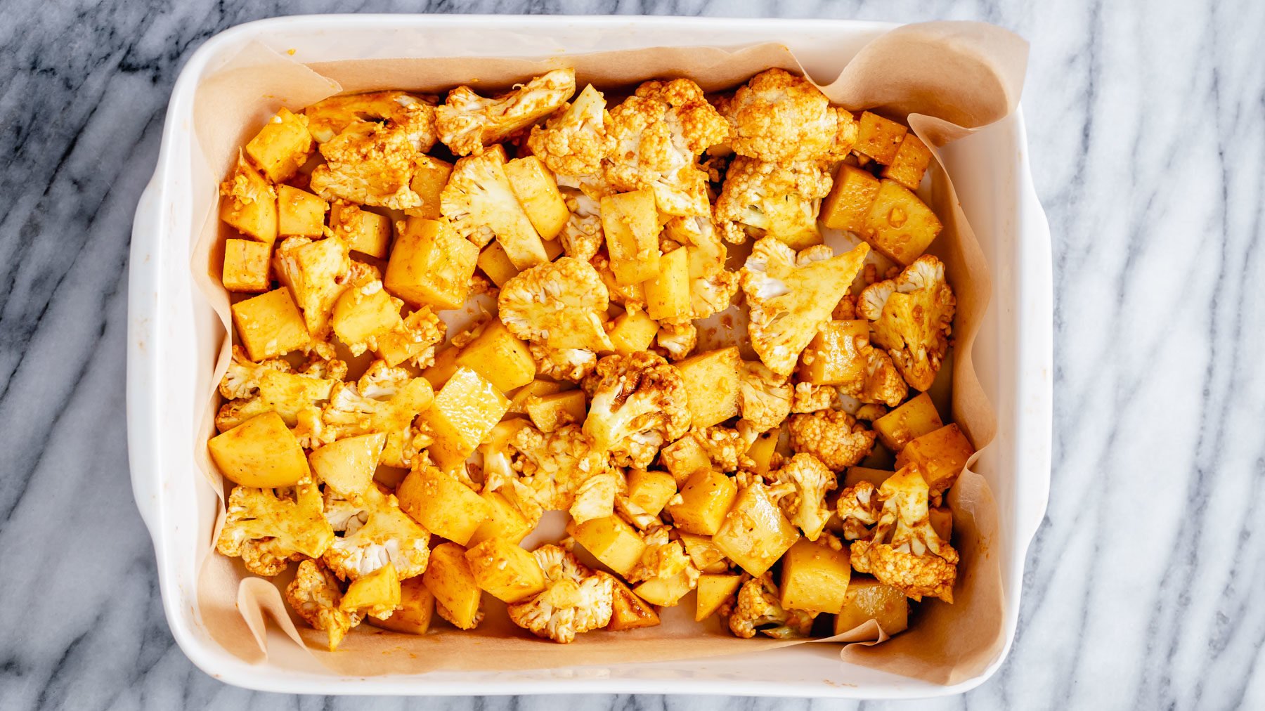vegan aloo gobi  cauliflower and potato cubes in a casserole dish
