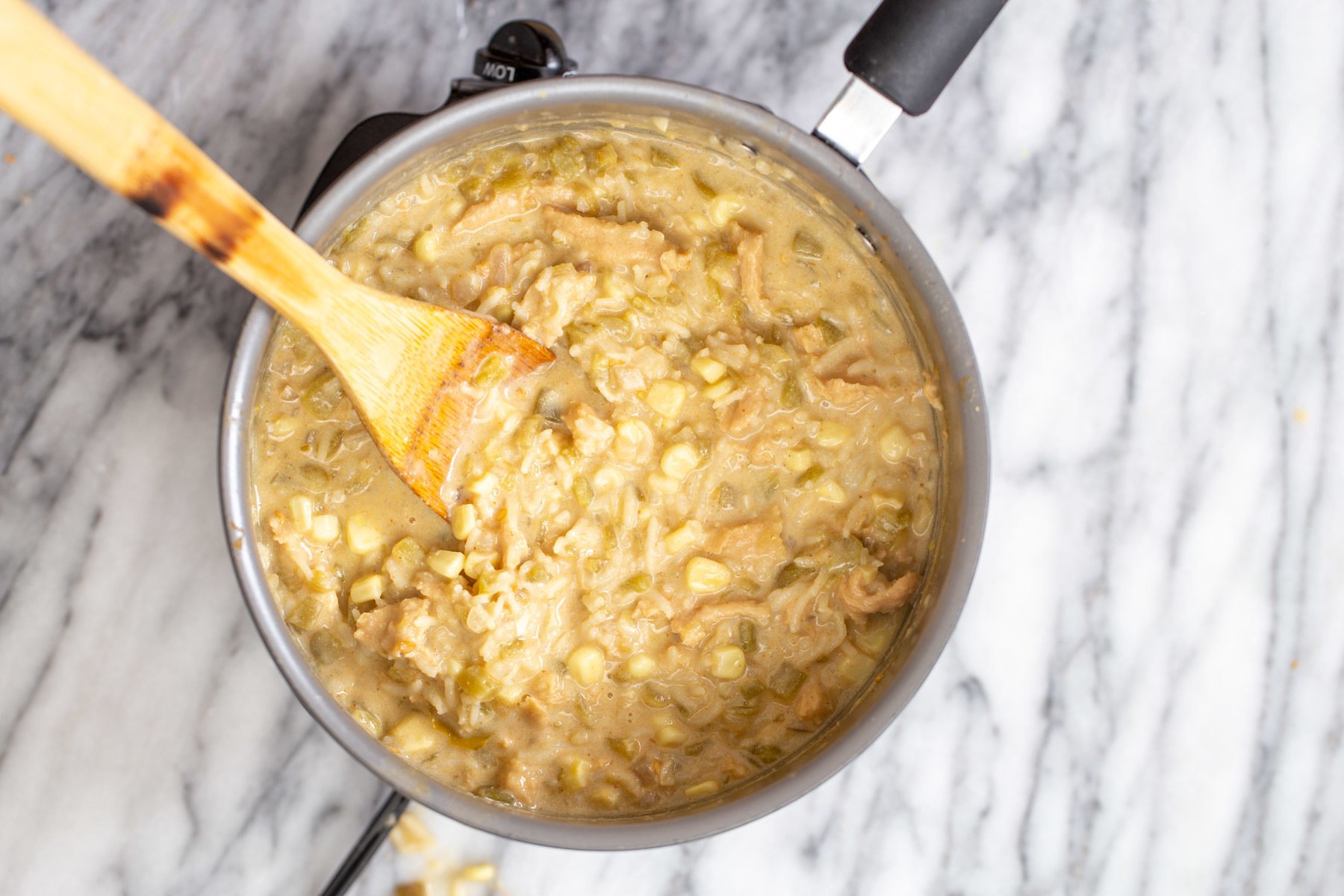 vegan enchilada soup  a pot of creamy vegan enchilada soup with a wooden spoon