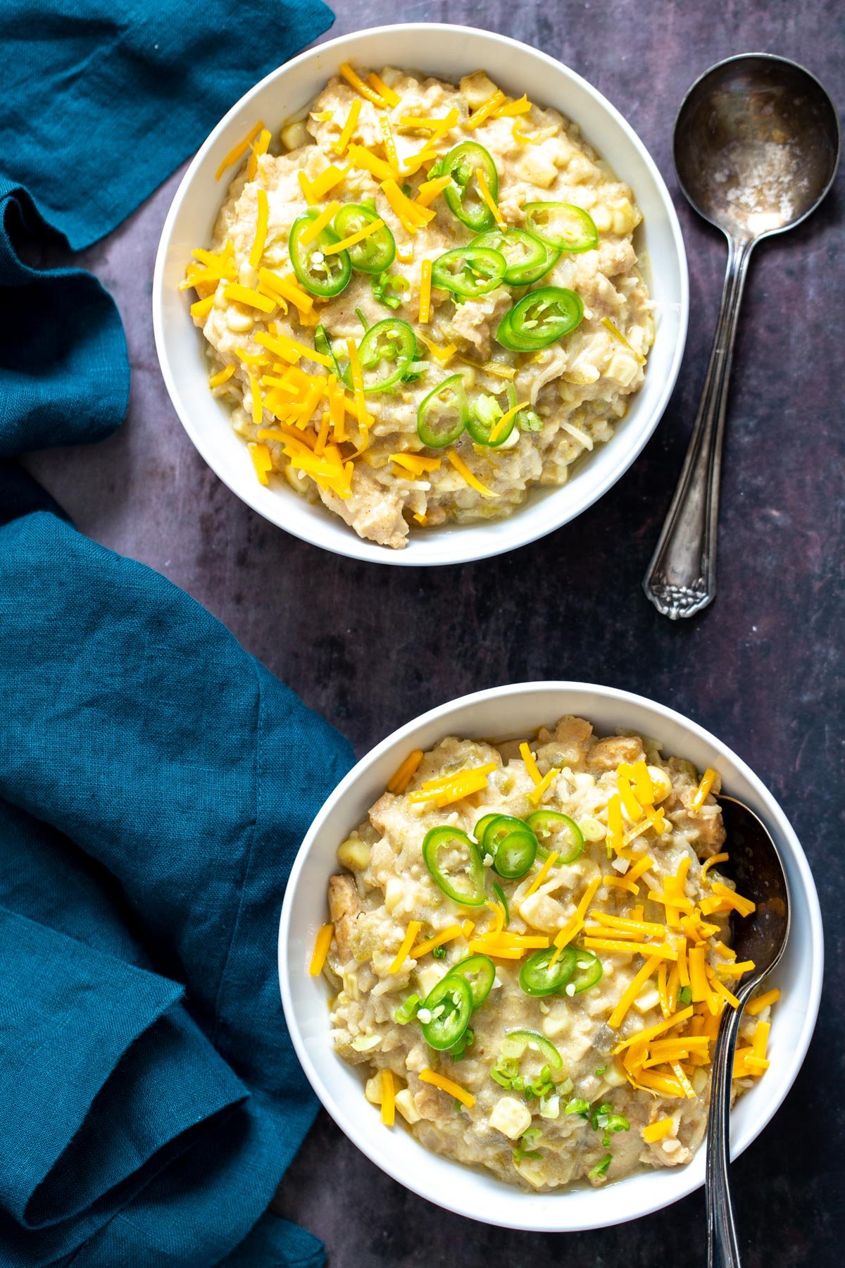 vegan enchilada soup two bowls of vegan green chile enchilada soup with shredded cheese and sliced green chiles