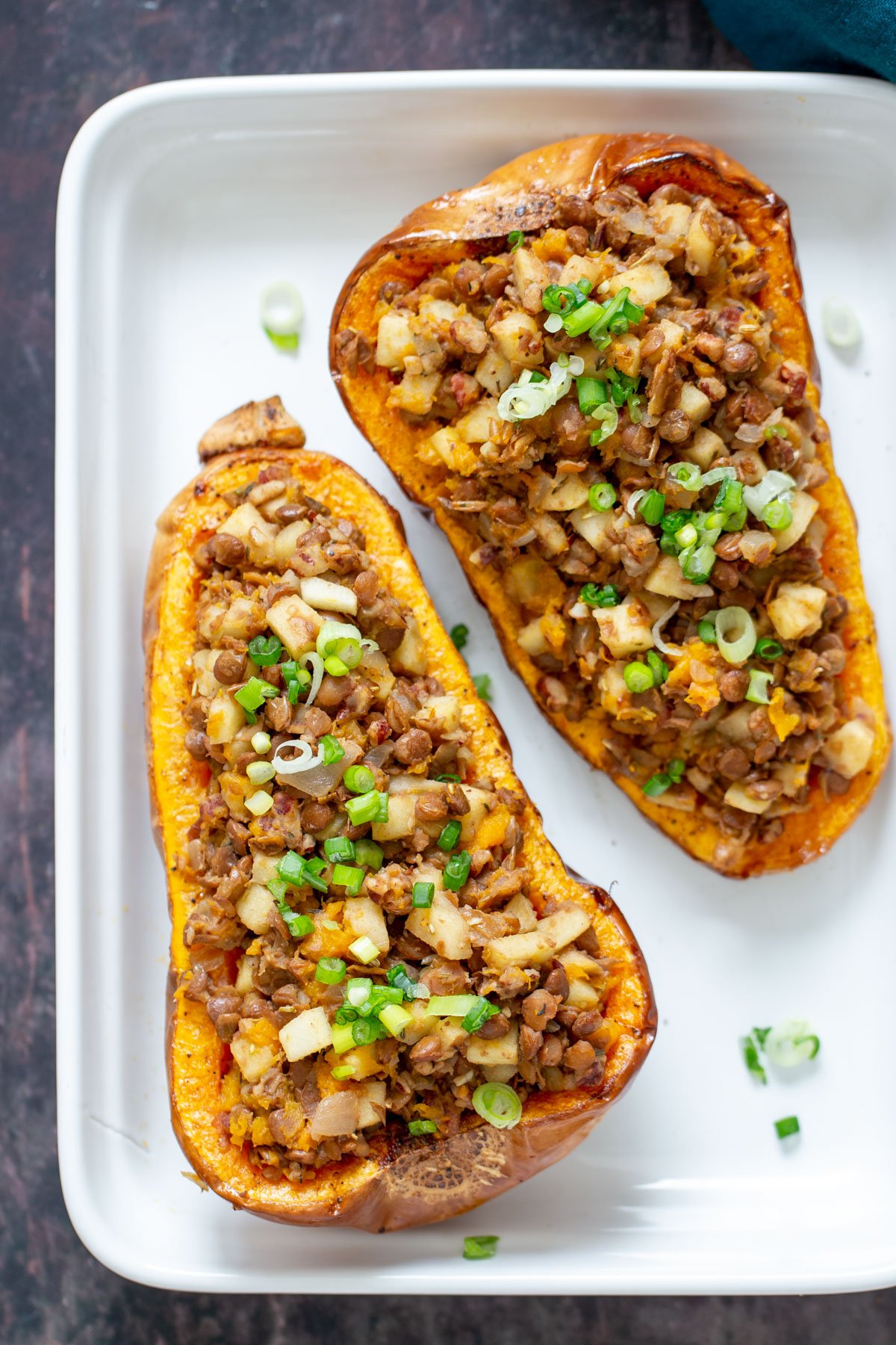 vegan stuffed butternut squash two stuffed butternut squash halves filled with apple and lentil stuffing