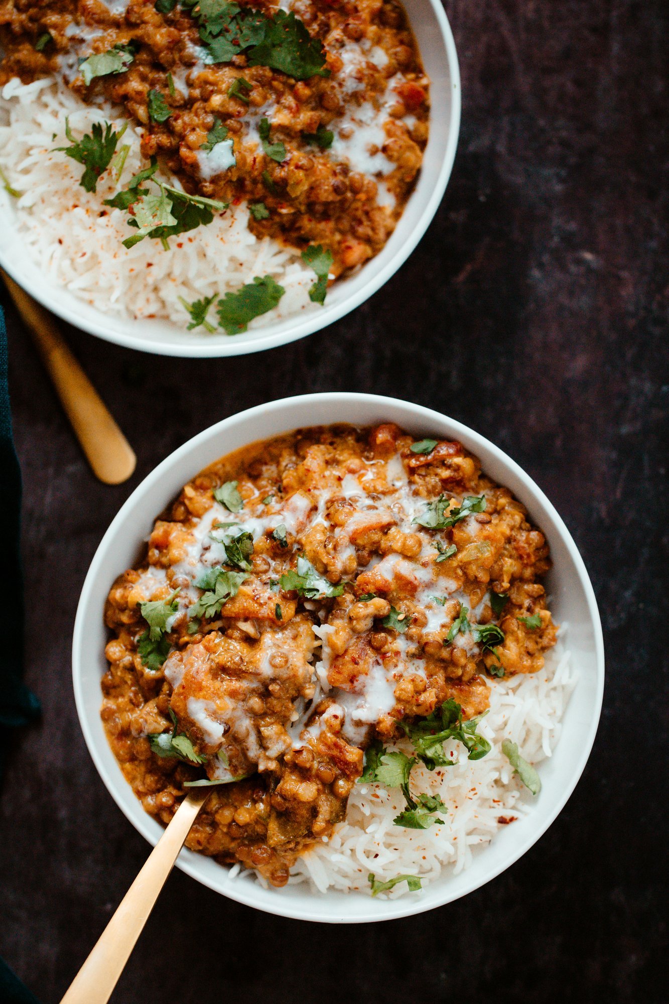 lentil casserole two bowl with rice and creamy coconut lentils sprinkled with cilantro and drizzled with coconut milk