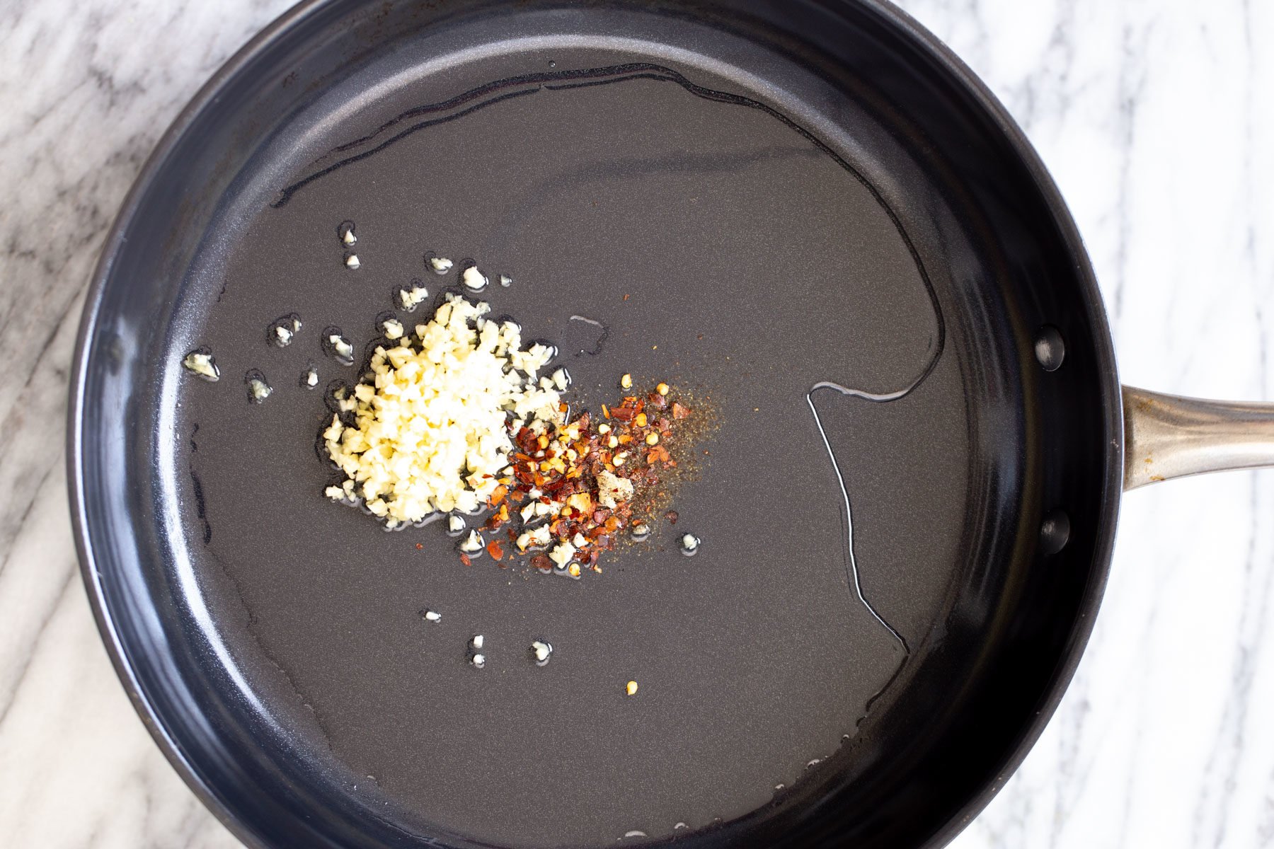 garlic and red pepper flaked being fried in oil to make vegan breakfast recipe