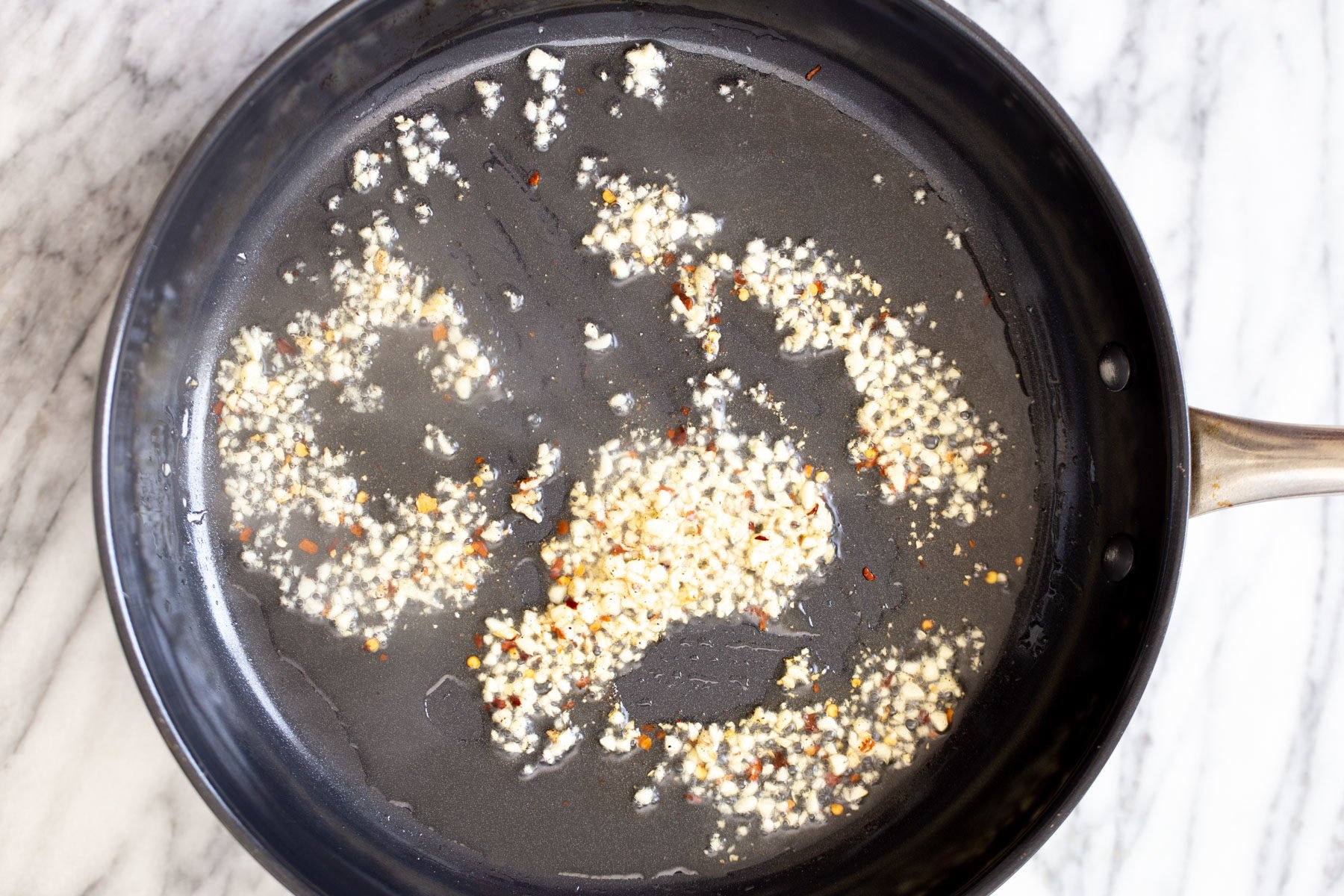 minced garlic and chili frying in a pan
