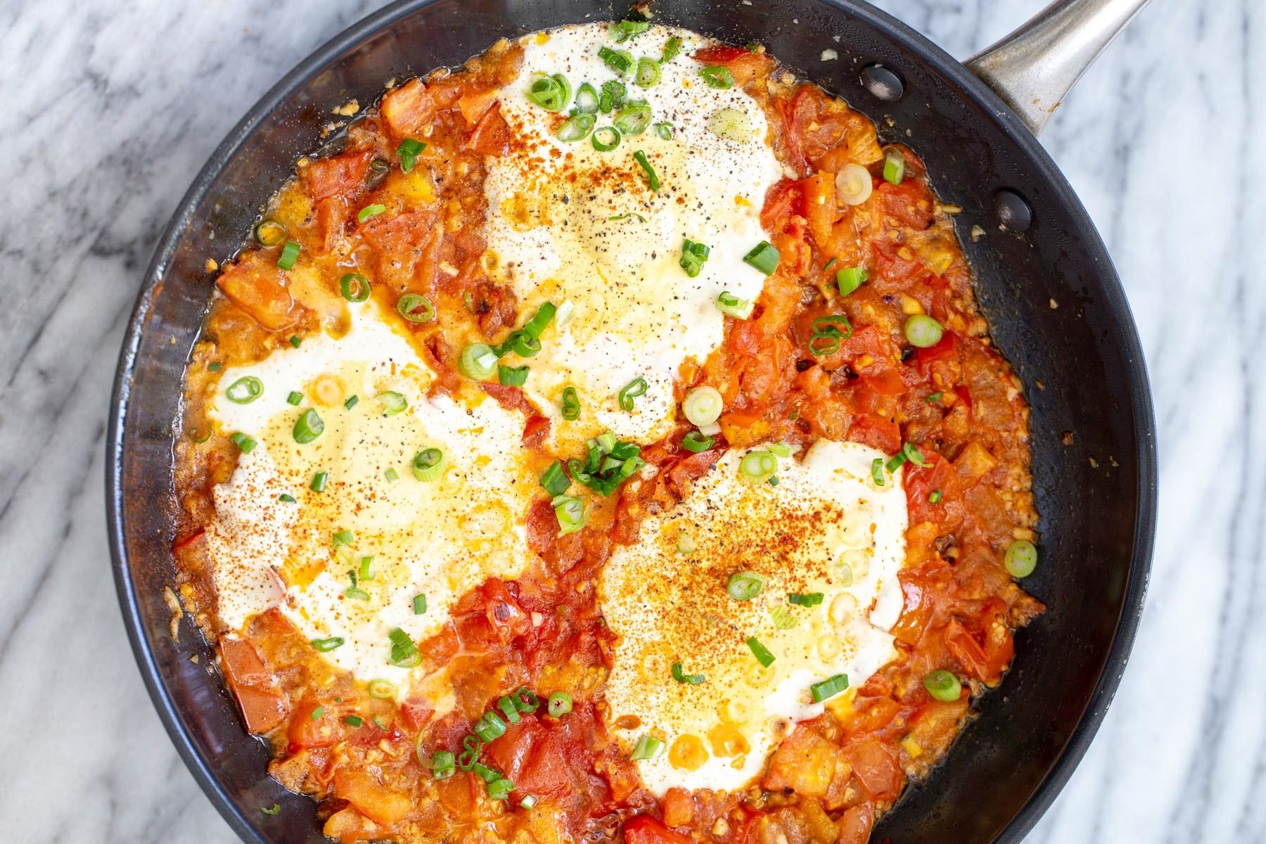 overhead shot of a skillet with vegan eggs in purgatory