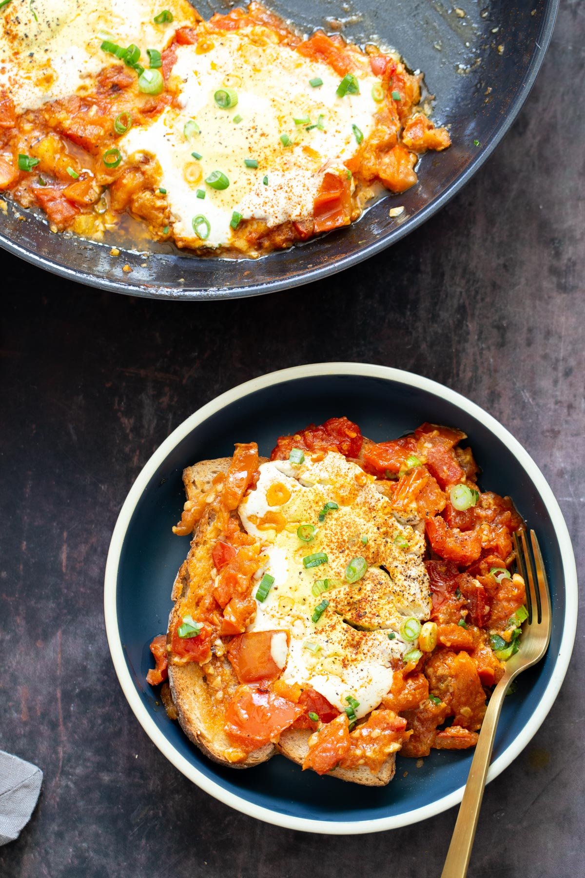 vegan eggs in purgatory a serving of vegan tofu eggs in purgatory in a blue bowl with a golden fork on the side