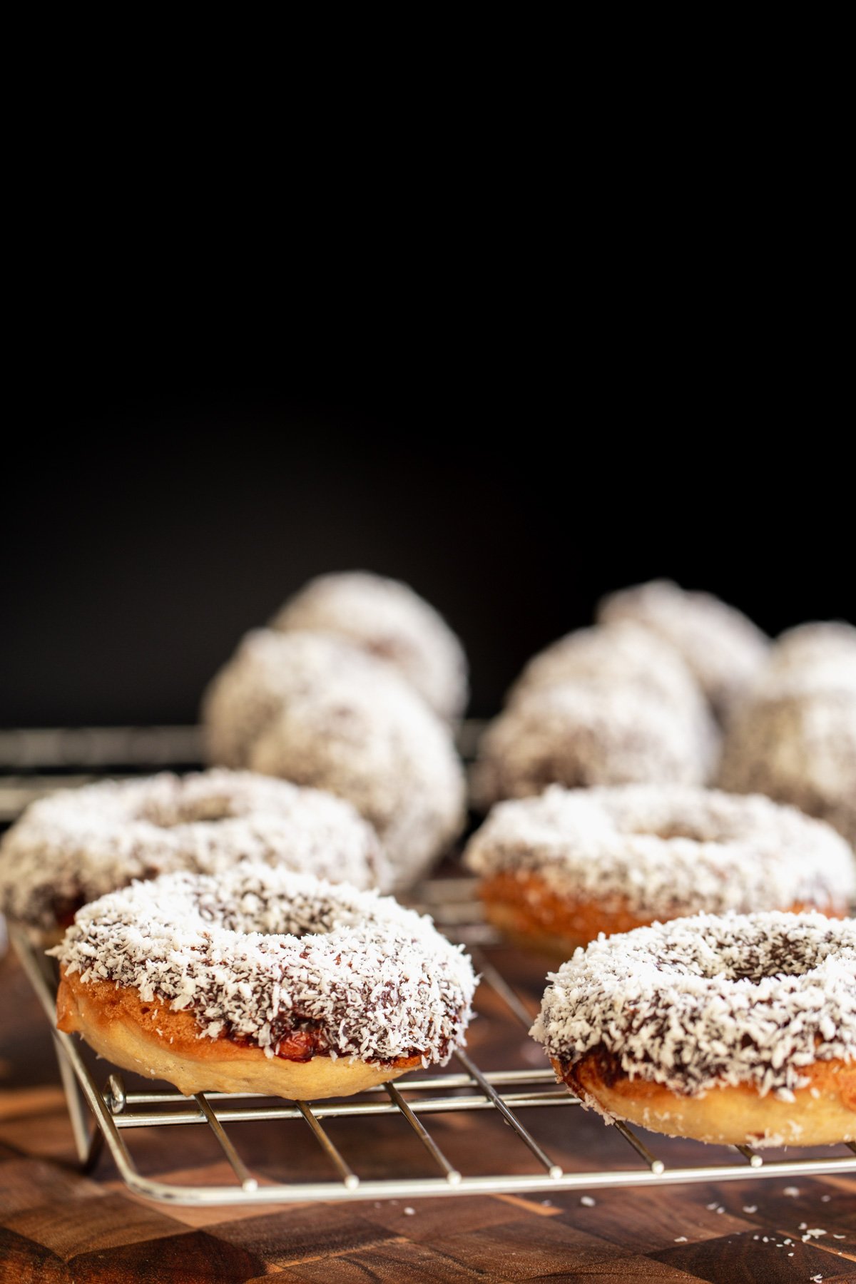 vegan lamington donuts  side view of vegan lamington donuts and donuts holes cooling on a cooling rack