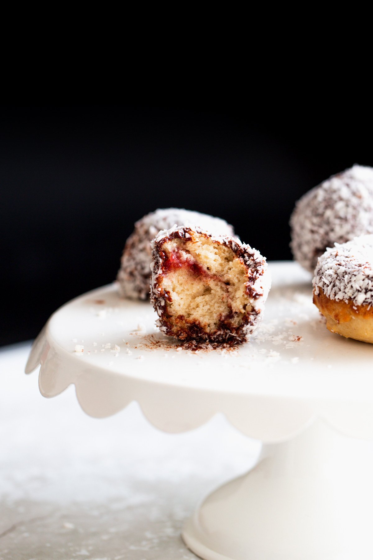 lamington donuts half a vegan lamington donut hole with one bite taken