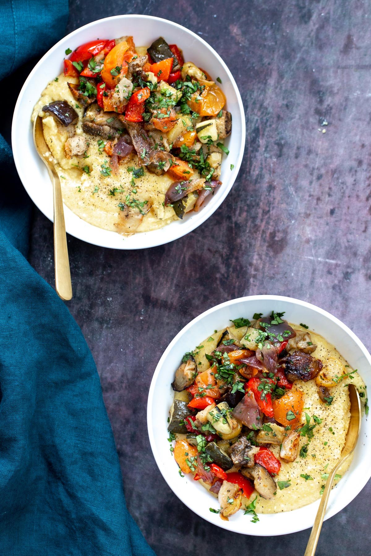 two servings of sheet pan ratatouille served in bowls over polenta