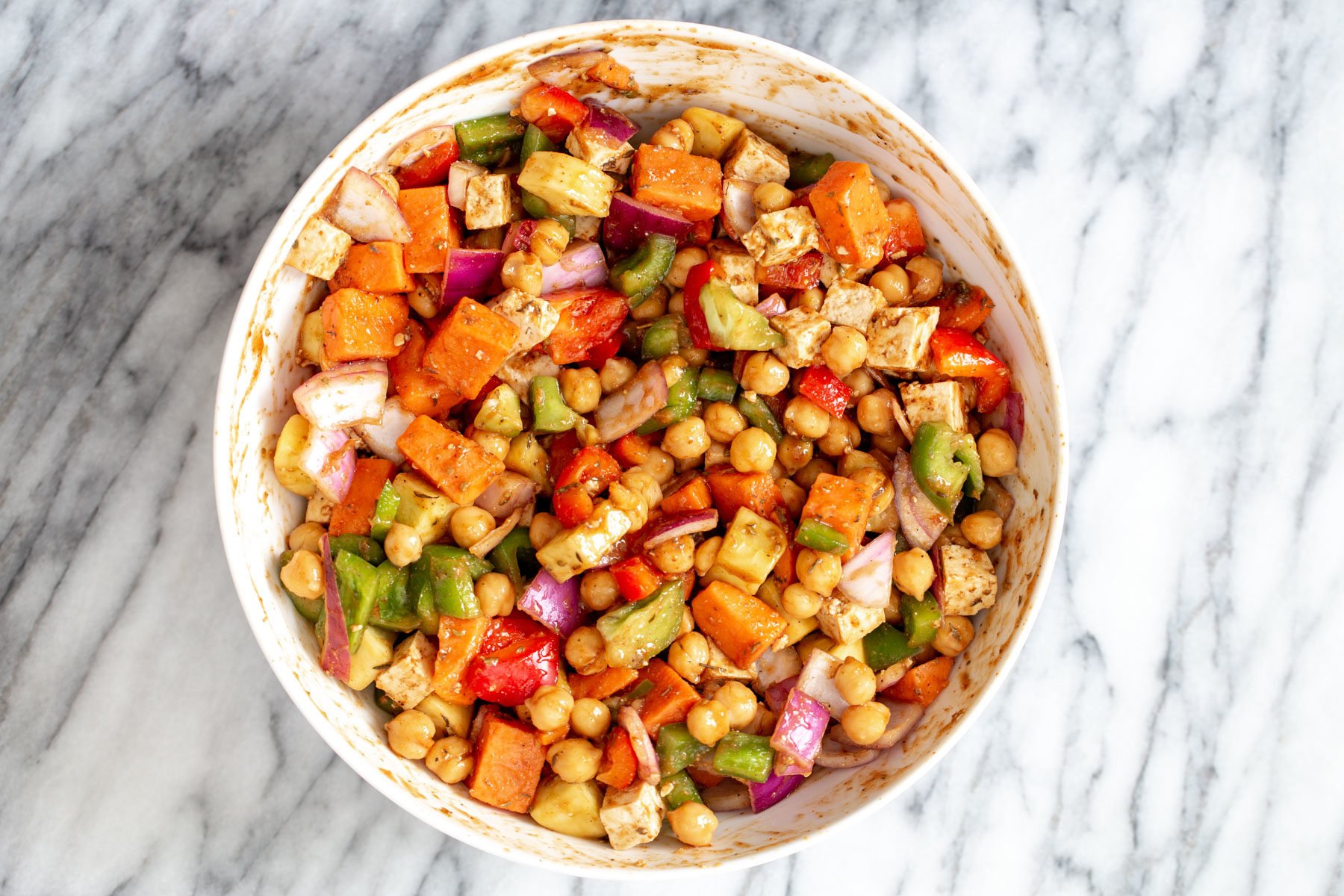 sheet pan cheeseburger vegetables being tossed with cheeseburger sauce