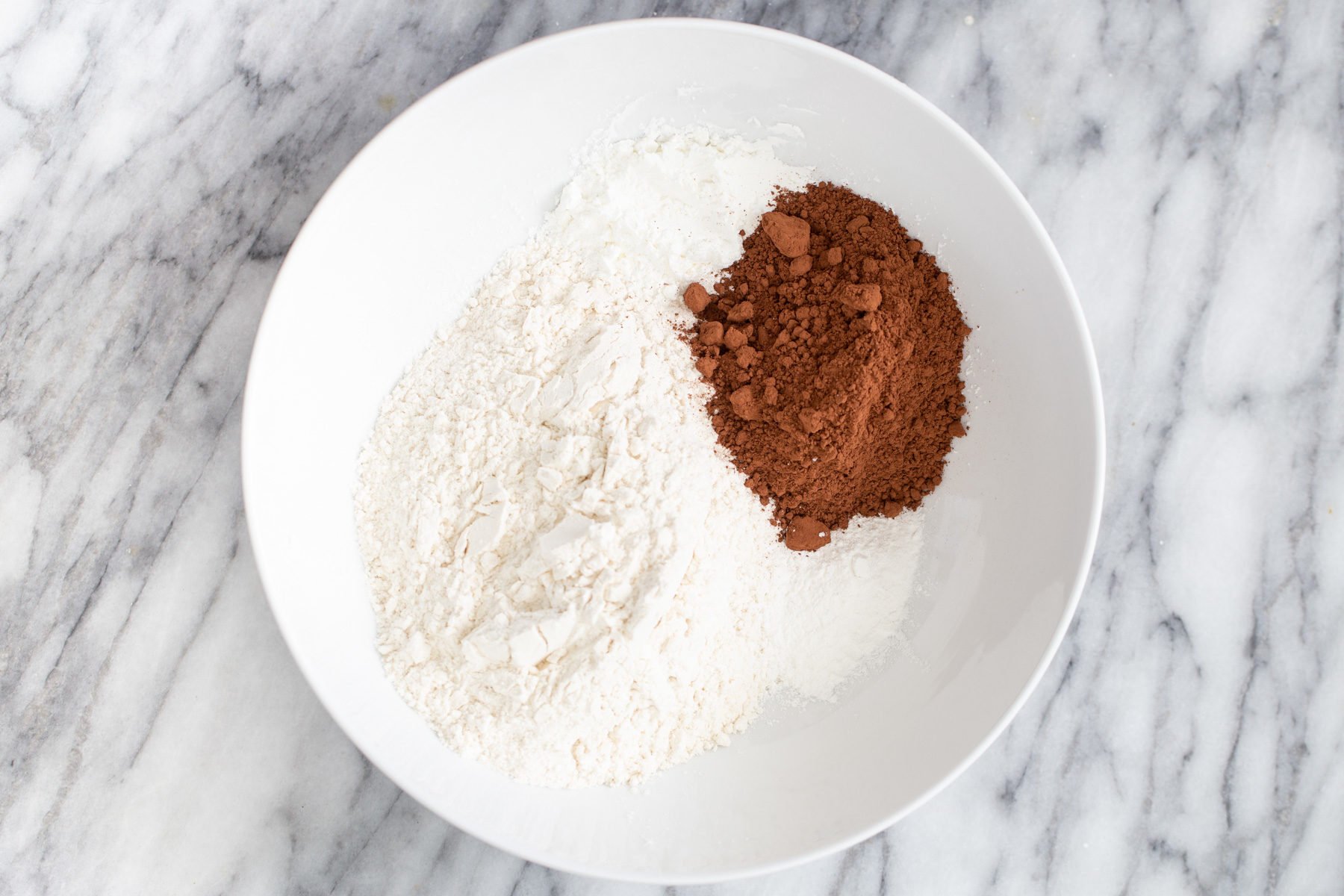 dry ingredients needed for German chocolate loaf cake recipe in a white bowl