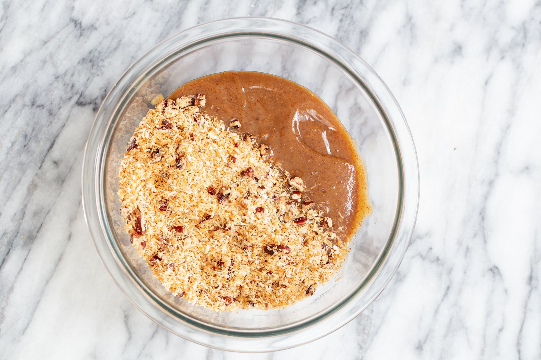date caramel being mixed with shredded coconut and pecans for German chocolate cake recipe