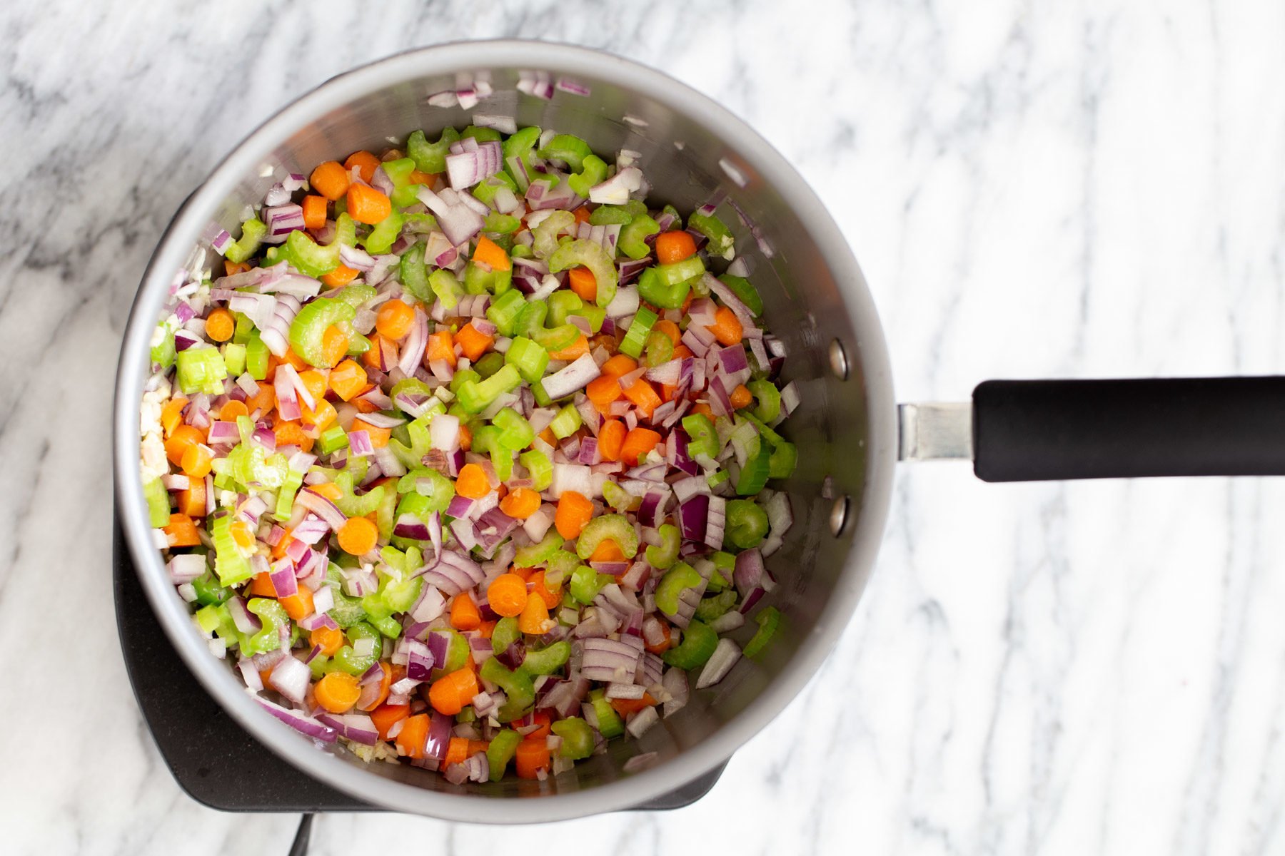 vegan pasta e fagioli celery carrots and onions sauteeing in a saucepan