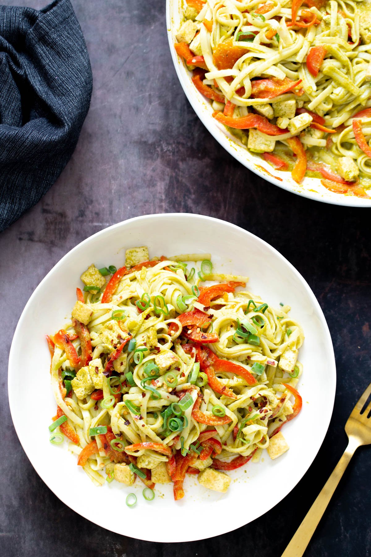 Thai Green Curry Noodles  two servings of Thai green curry noodles with bell peppers and green onion with a fork on the side