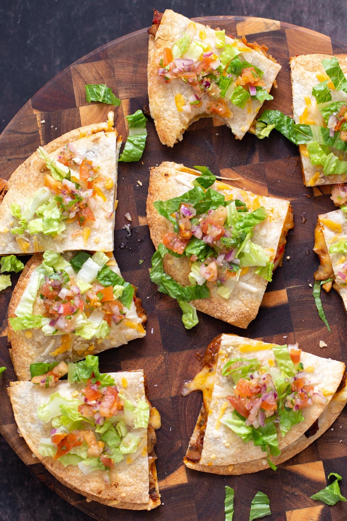 vegan tostadas  vegan mushroom and bell pepper tostadas cut into wedges and served on a wooden board