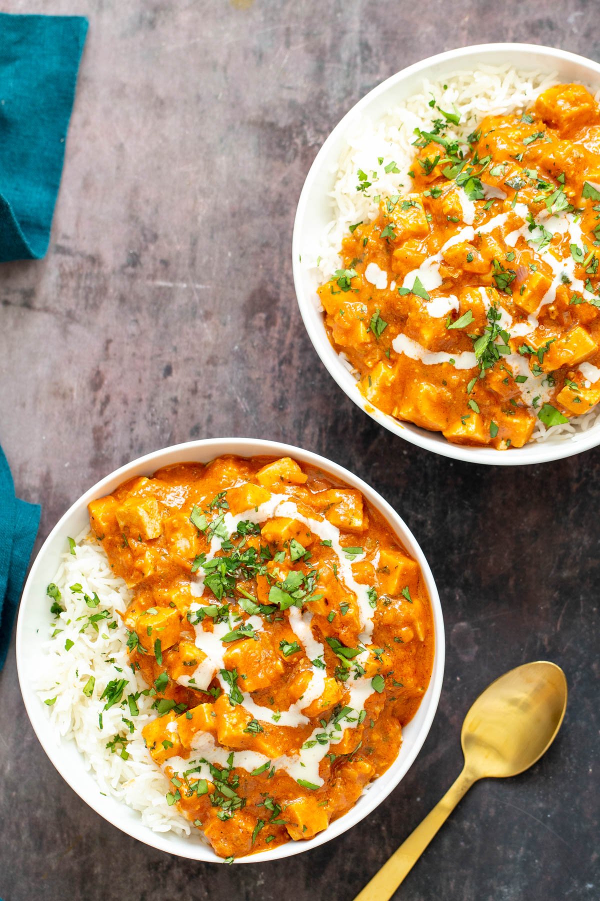 baked tofu curry  two bowl with Indian vegan baked tofu curry served over fluffy rice with a golden spoon on the side