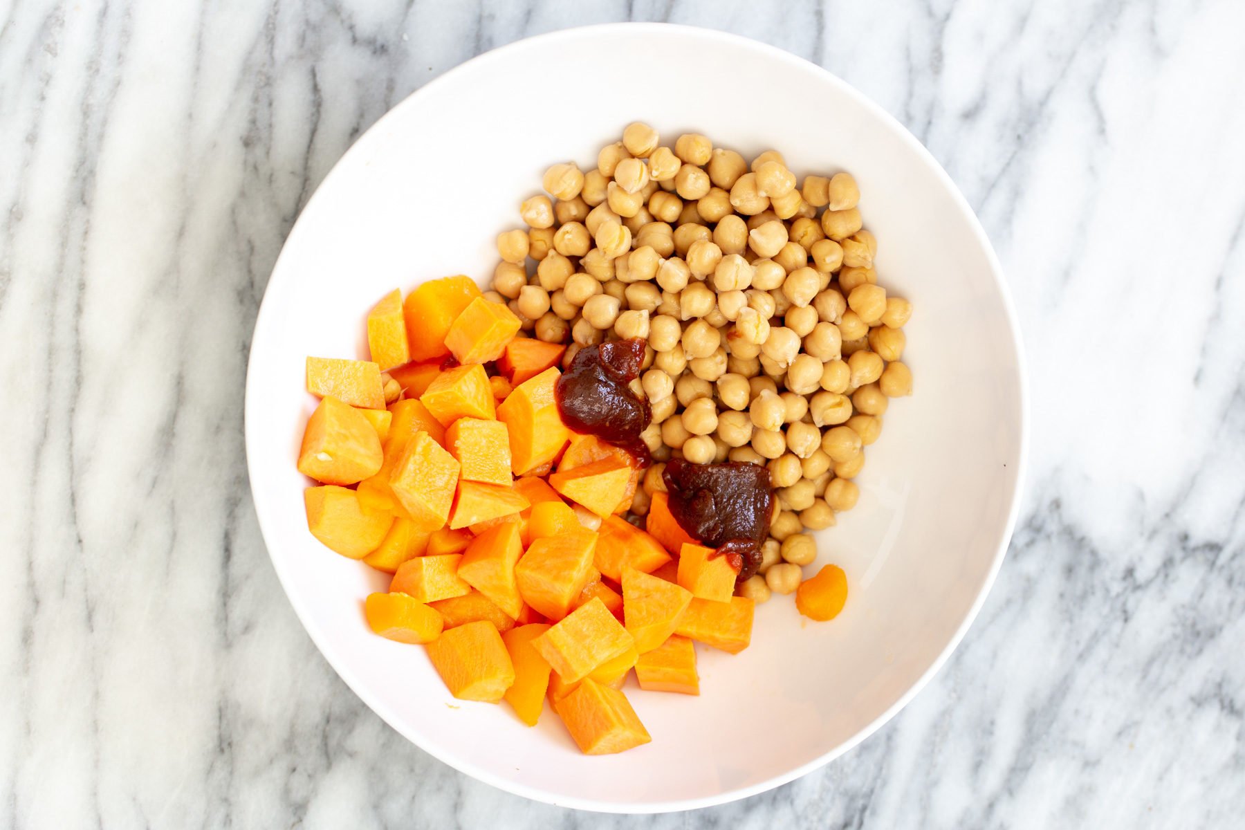 sweet potatoes and chickpeas in a bowl with some bbq sauce