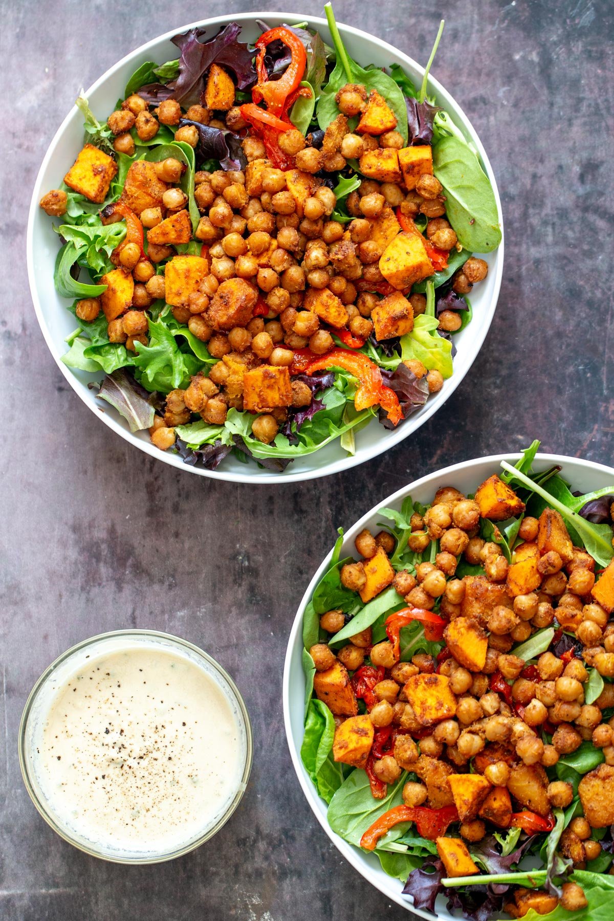 sweet potato chickpea salad  sweet potato chickpea salad in two bowls with a small side dish with tahini sauce