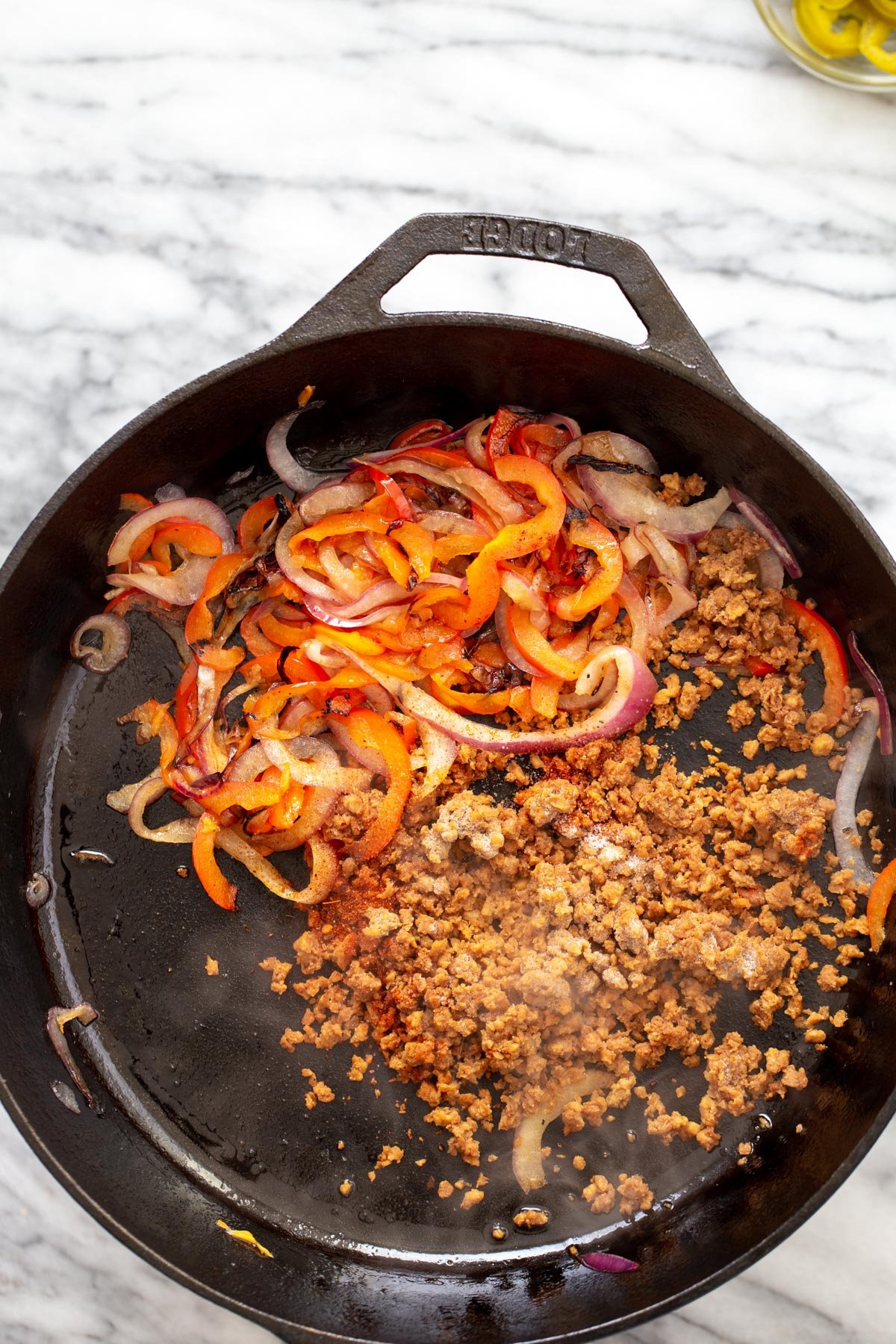 veggie crumbles bell pepper and onion in a black skillet