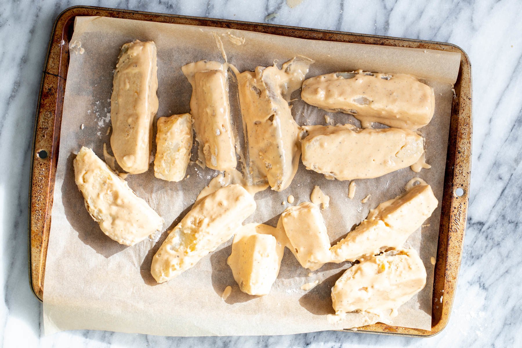 jo jo potatoes battered breaded jo jo potatoes on a sheet pan ready to be baked