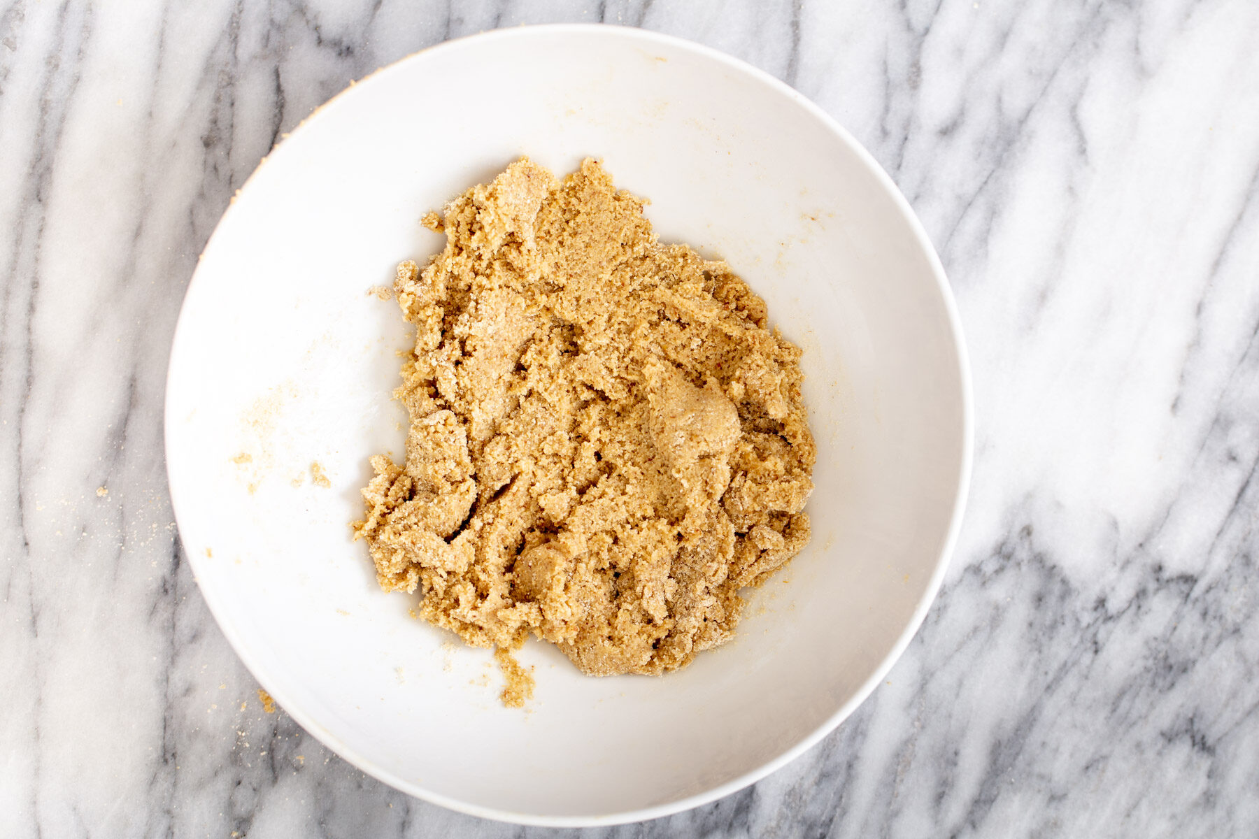 vegan lemon bars  vegan cookie crust made from oatmeal and almond flour being mixed in a bowl