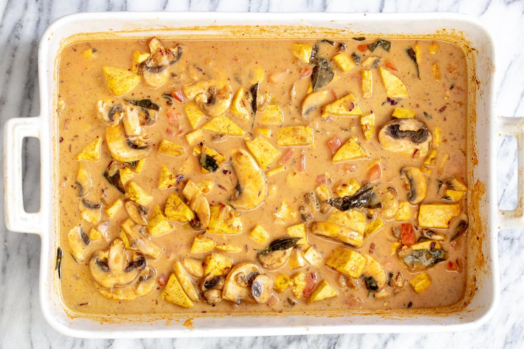 Indian coconut milk and curry tofu casserole ready for baking