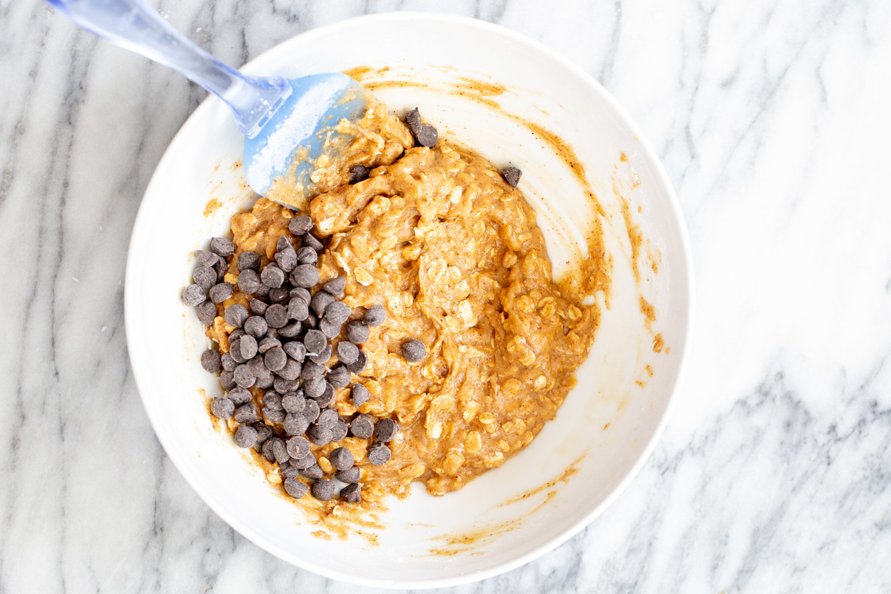 chocolate chips being added to vegan oatmeal bar base 