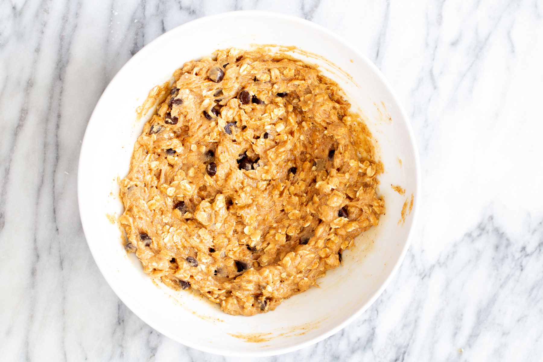 vegan carmelita oatmeal batter with chocolate chips in a mixing bowl 