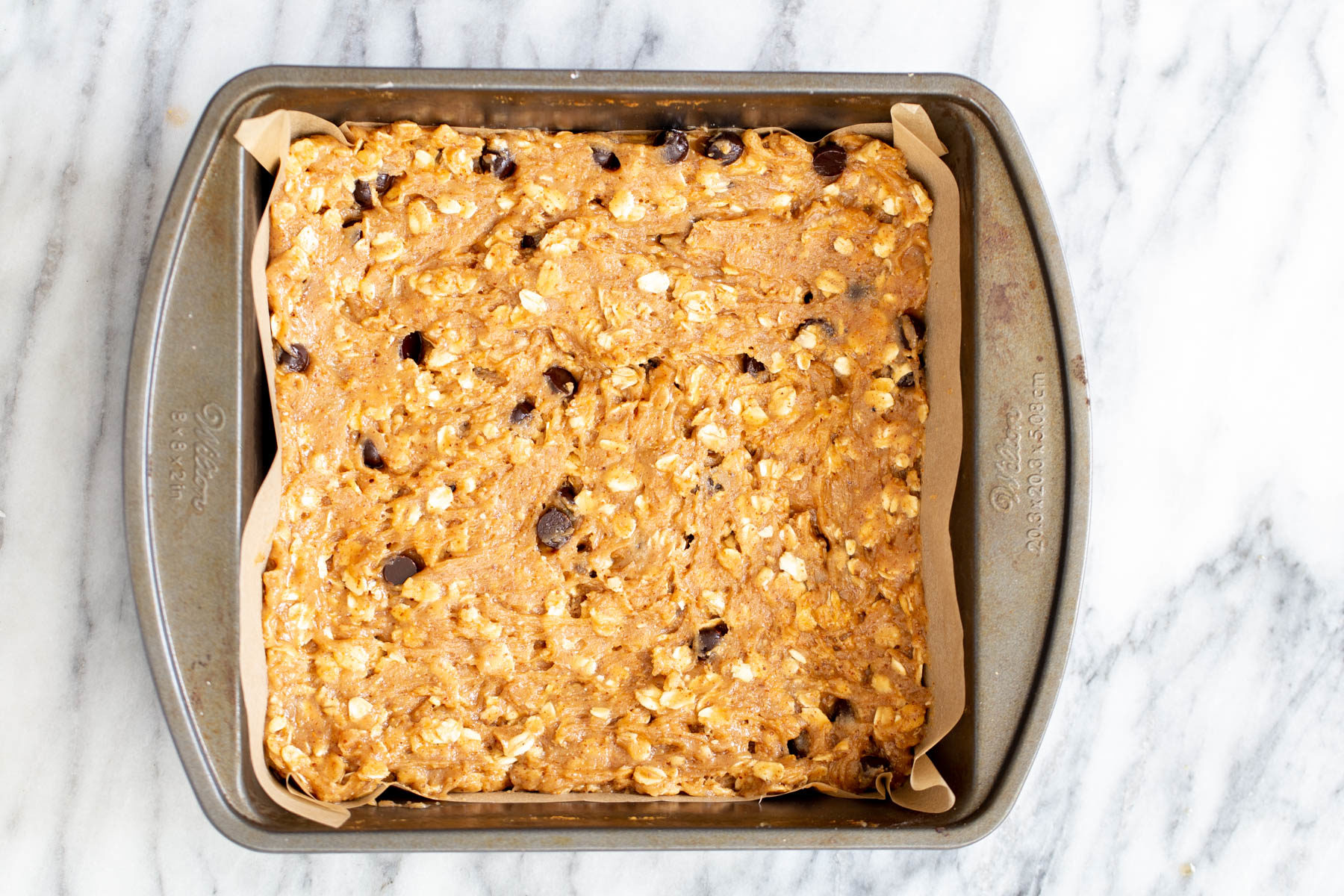 oatmeal bar batter in a square brownie pan 