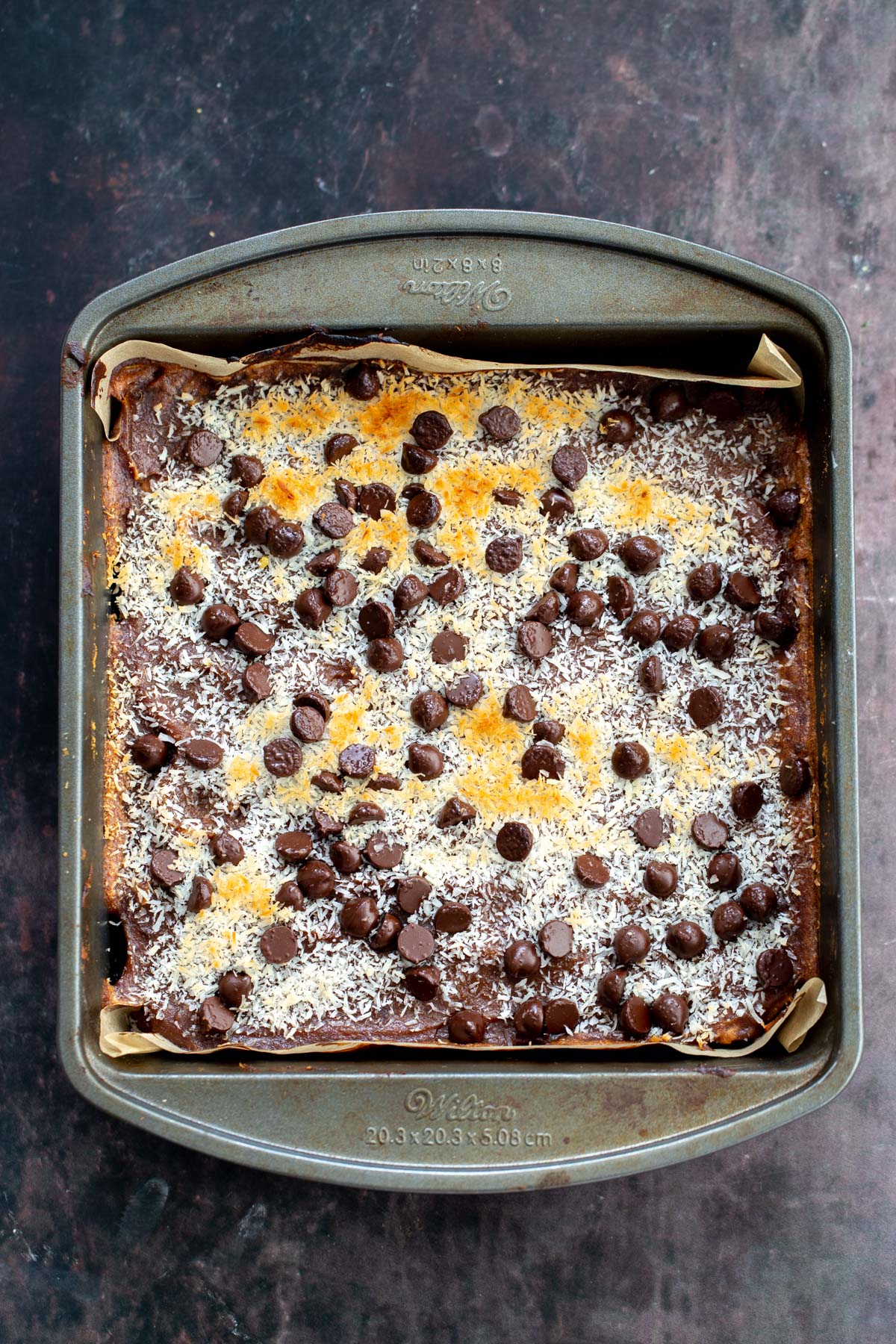 freshly baked vegan carmelita oatmeal caramel bars in a baking pan 