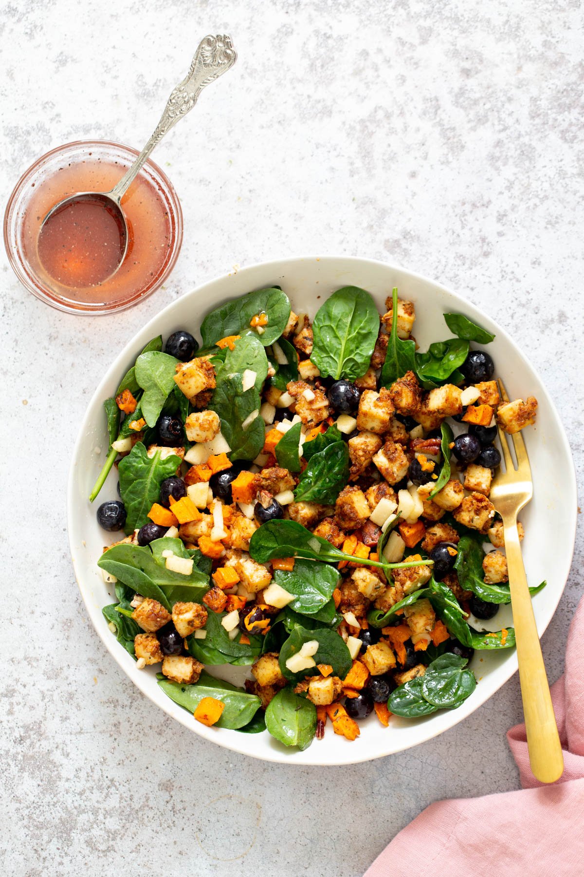 sweet potato tofu bowl  sweet potato tofu bowls with blueberries and chunks of apple tossed in a shallow white bowl with maple mustard dressing