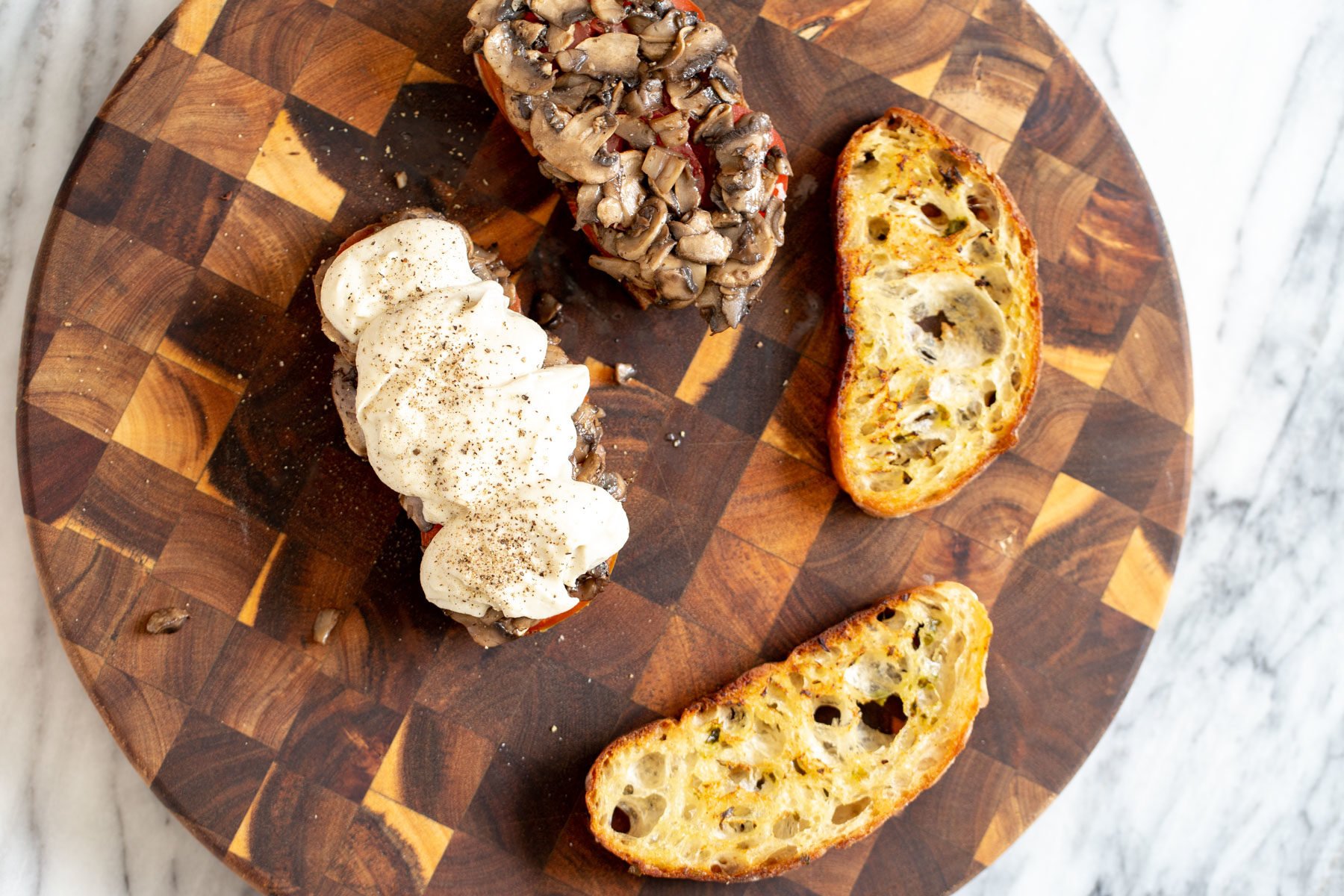 vegan cheese melts  bread sliced being topped with sauteed mushrooms and vegan mozarella cheese