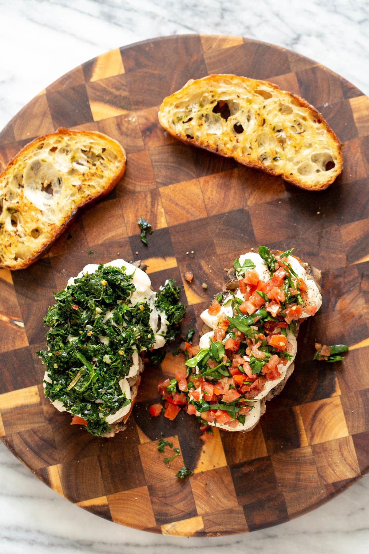 overhead shot of vegan cheese melts topped with homemade cashew mozzarella spinach and tomatoes